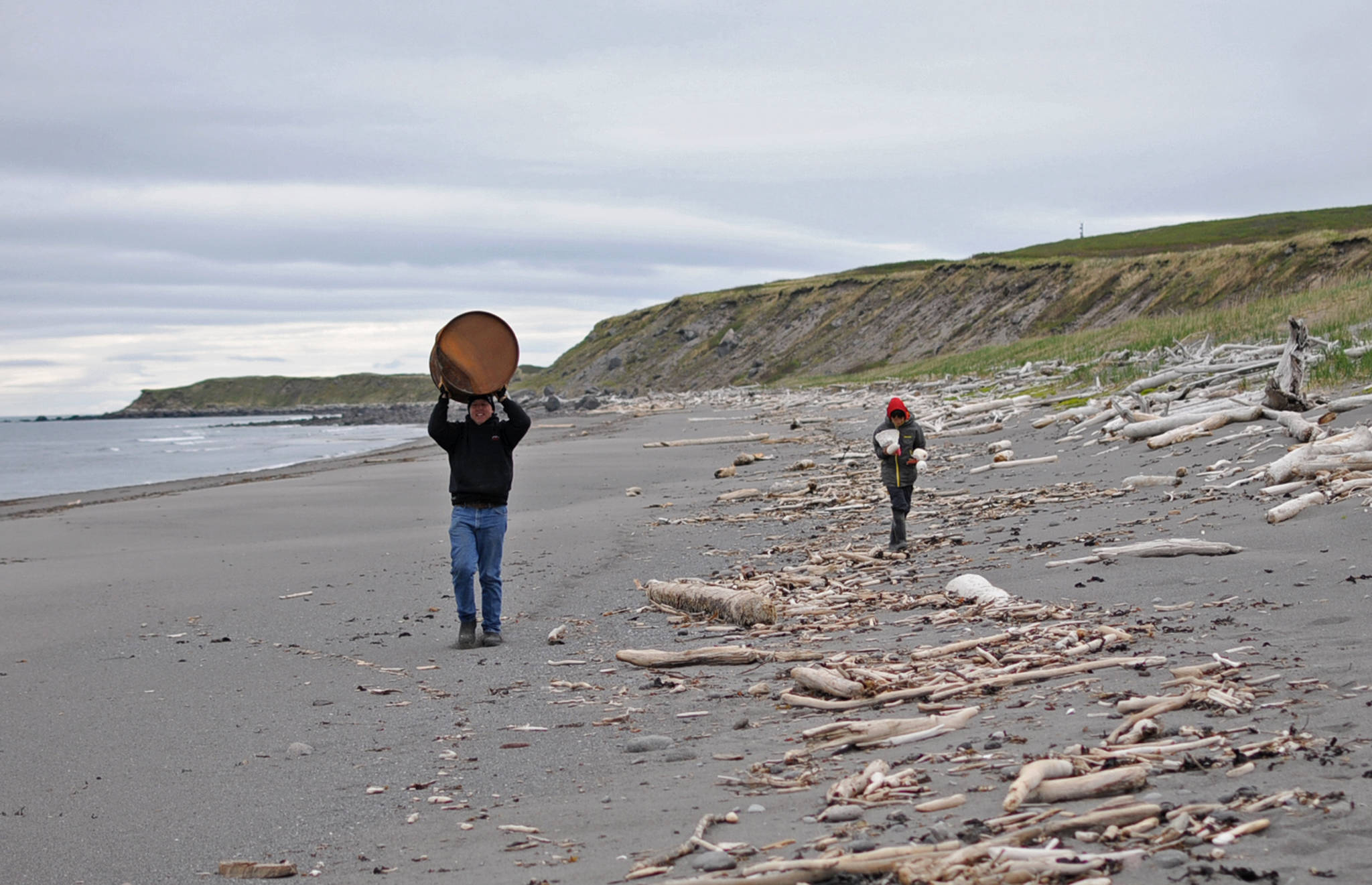 Homer Mayor Bryan Zak (left), who also serves on the board of directors of the Center for Alaskan Coastal Studies, carries back a rusted barrel along the beach with Connections student Gautama Iwamura (right) on Sunday, June 3, 2017 on Augustine Island, Alaska. The two were participants in a trip organized by the Center for Alaskan Coastal Studies to clean up the beaches of the remote Cook Inlet island, composed mostly of an active volcanot and its surrounding debris. (Elizabeth Earl/Peninsula Clarion)  Homer Mayor Bryan Zak (left), who also serves on the board of directors of the Center for Alaskan Coastal Studies, carries back a rusted barrel along the beach with Connections student Gautama Iwamura (right) on Sunday on Augustine Island. The two were participants in a trip organized by the Center for Alaskan Coastal Studies to clean up the beaches of the remote Cook Inlet island, composed mostly of an active volcanot and its surrounding debris. (Elizabeth Earl/Peninsula Clarion)