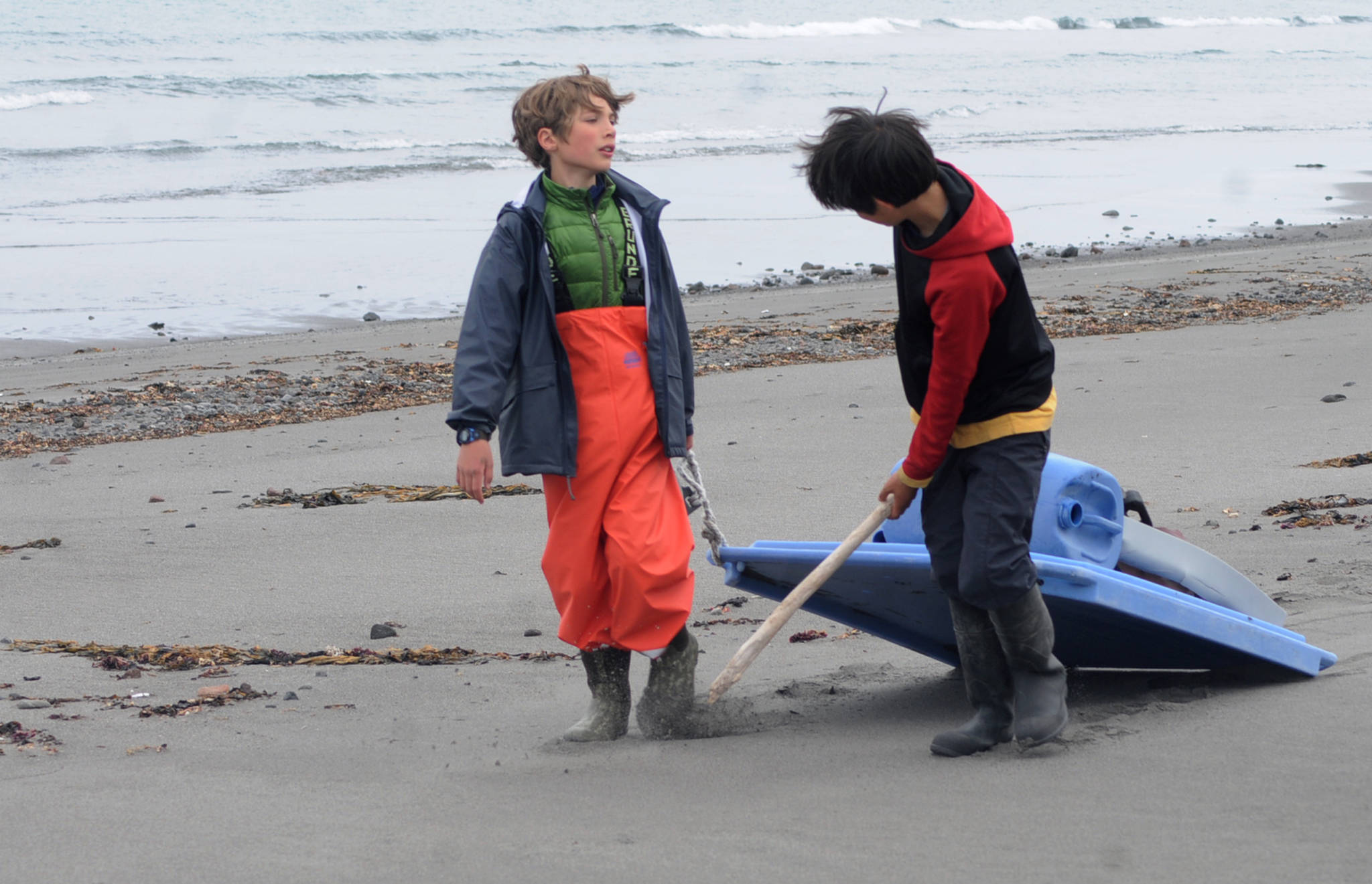 Johannes Bynagle (left) and Gautama Iwamura, both homeschool students through the Kenai Peninsula Borough School District Connections program, tug a makeshift sled loaded with marine debris down the beach on Sunday, June 3, 2017 on Augustine Island, Alaska. The two were participants in a trip organized by the Homer-based nonprofit Center for Alaskan Coastal Studies to clean up debris along the beaches of the remote island in Cook Inlet. (Elizabeth Earl/Peninsula Clarion)  Johannes Bynagle (left) and Gautama Iwamura, both homeschool students through the Kenai Peninsula Borough School District Connections program, tug a makeshift sled loaded with marine debris down the beach on Sunday on Augustine Island. The two were participants in a trip organized by the Homer-based nonprofit Center for Alaskan Coastal Studies to clean up debris along the beaches of the remote island in Cook Inlet. (Elizabeth Earl/Peninsula Clarion)