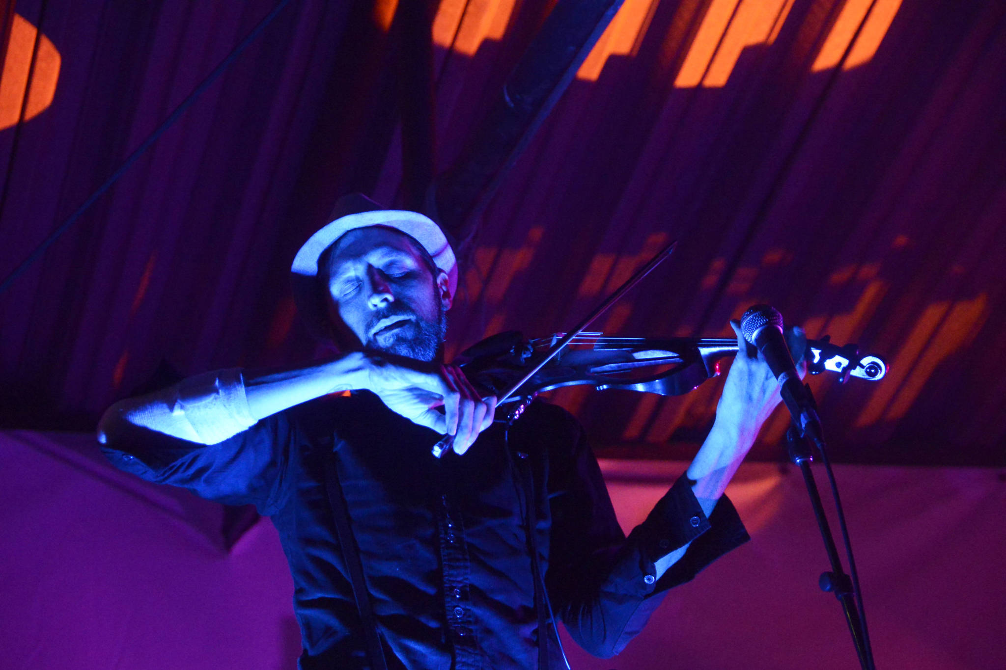Shane Borth, a violinist and composer for Quixotic, plays during the group’s performance Aug. 7, 2016 at Salmonfest in Ninilchik, Alaska. Quixotic is a cirque nouveau that blends live music with dance, lights and other performance art. Photo by Megan Pacer/Peninsula Clarion