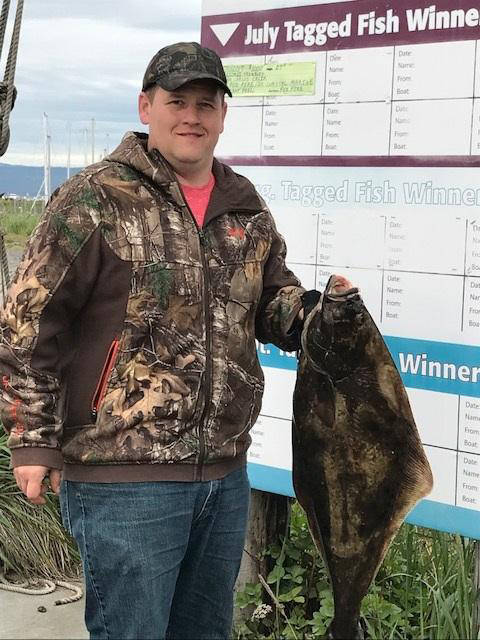 Jasen VanMieuwenhover of Wisconsin holds a left-hand halibut he caught fishing July 11 with Homer Ocean Charters, who also sold him his derby ticket. The $100 prize for a lefty was sponsored by Timer Bay B&B.