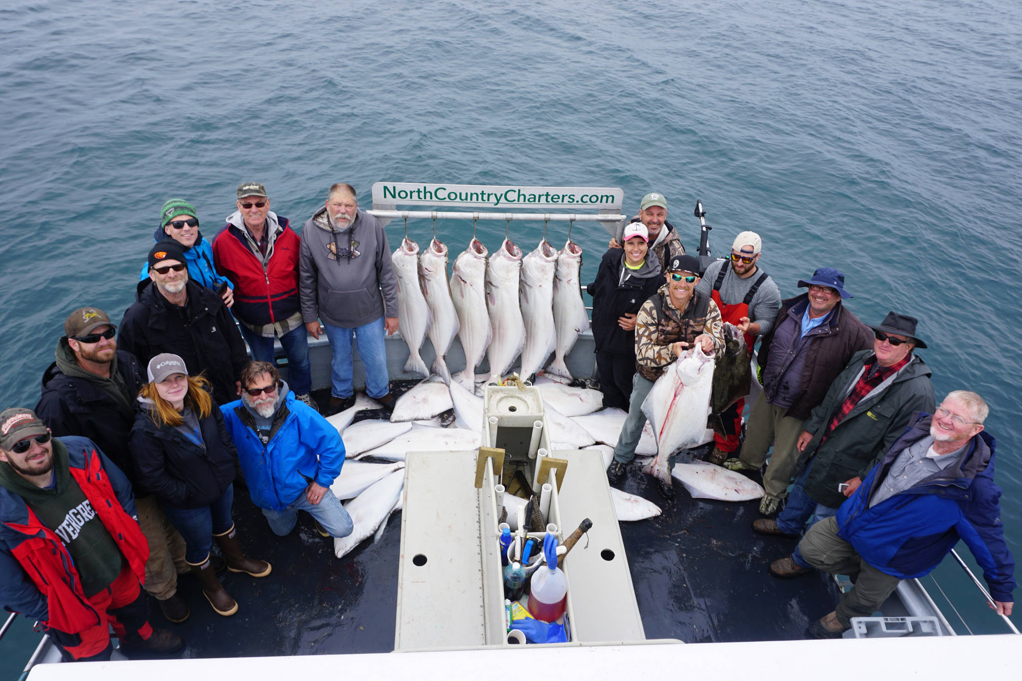 Anglers stand by a rack of halibut on the Irish as the North Country Charters boat returns to Homer. The 16 people fishing on the 53-foot boat all limited out on a July 16, 2017 guided halibut fishing trip out of Homer Alaska . Photo by Casey McKinnon