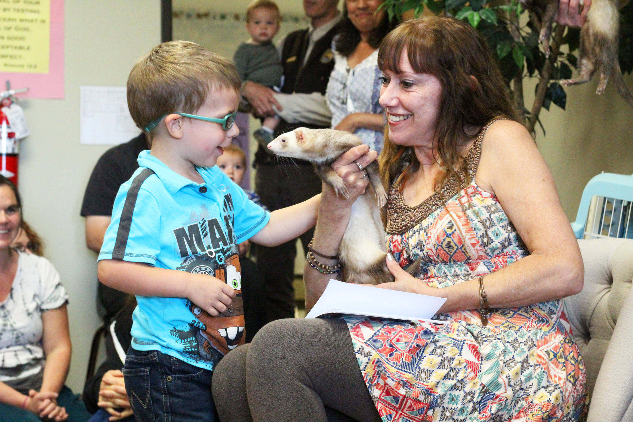 Photo by Megan Pacer/Homer News Homer resident Jeannette Aragones introduces her ferret, Oscar, to Jack Roderick during a special reading of her book, “I Am Oscar. I Am in Charge.” on Friday, July 21, 2017 at the Girassol Learning Center in Homer, Alaska.
