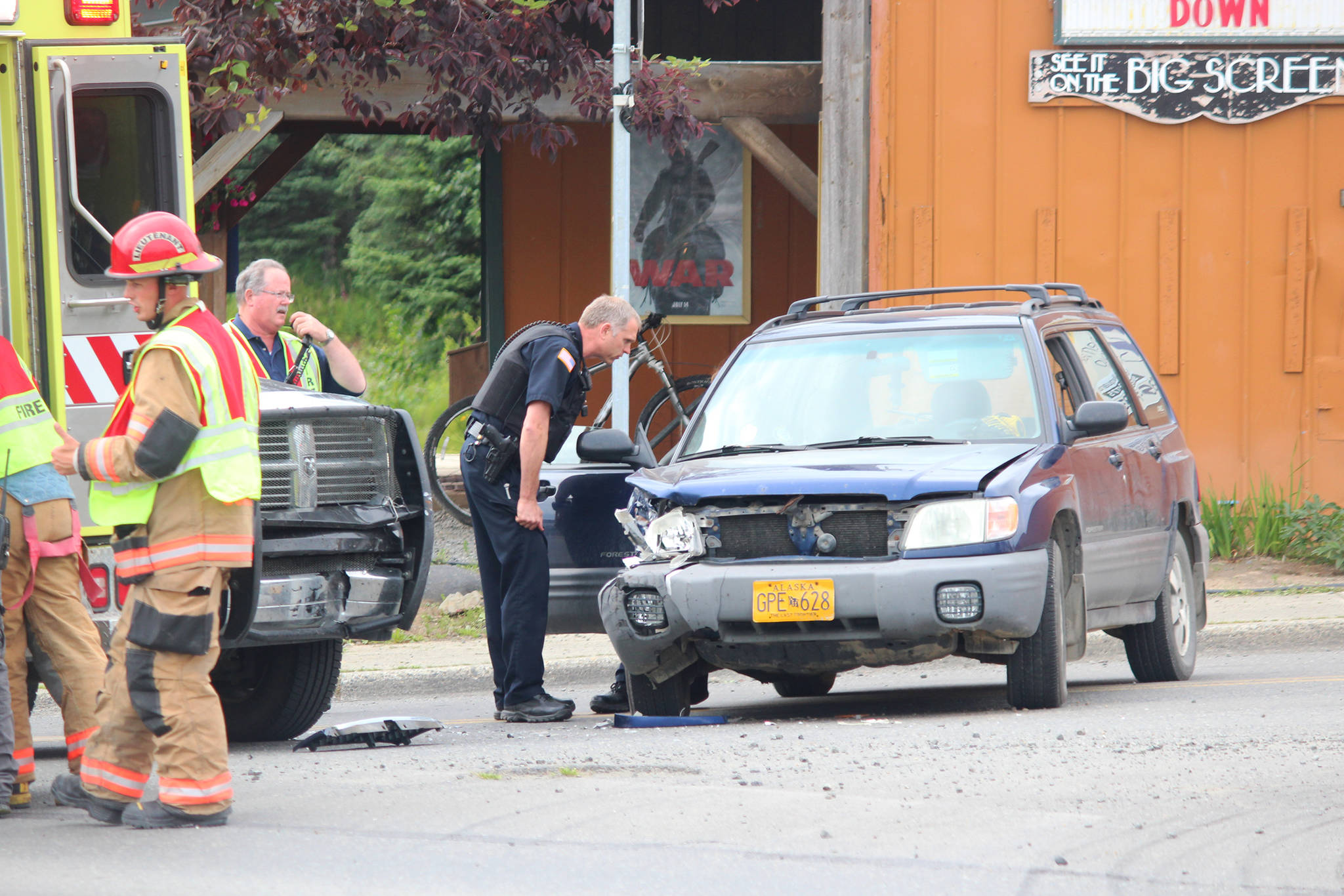 Members of the Homer Police Department and the Homer Volunteer Fire Department investigate the scene of a two-vehicle, head-on crash between a black pickup truck and a navy blue Subaru on Tuesday, July 25, 2017 at the intersection of Pioneer Avenue and Main Street in Homer, Alaska. One woman, the driver of the Subaru, was taken from the scene in an ambulance. The pickup was driven from the scene. Photo by Megan Pacer/Homer News