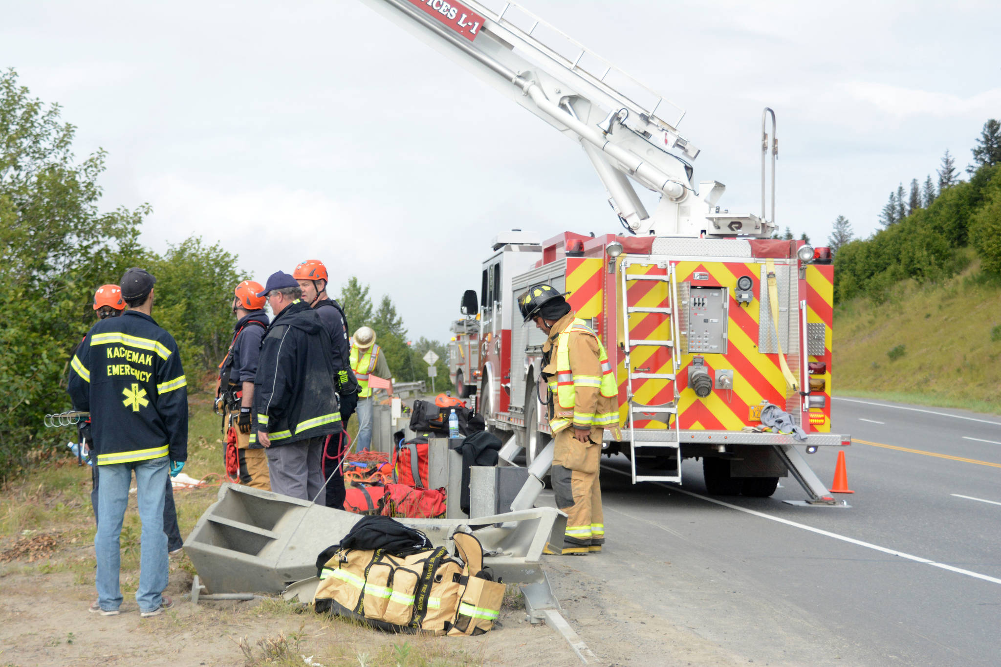 Kachemak Emergency Services and Homer Volunteer Fire Department firefighters search for possible crash victims in a ravine about noon Monday, July 24, 2017 at the Baycrest Hill turnout in Homer, Alaska. Rescuers found a truck that had plunged over the edge, but did not find any victims. The truck hit and bent the guardrail in the foreground. Friends of Thayr Watson, 32, later stopped by the scene to tell them Watson had crashed the truck earlier and was OK. Photo by Michael Armstrong/Homer News