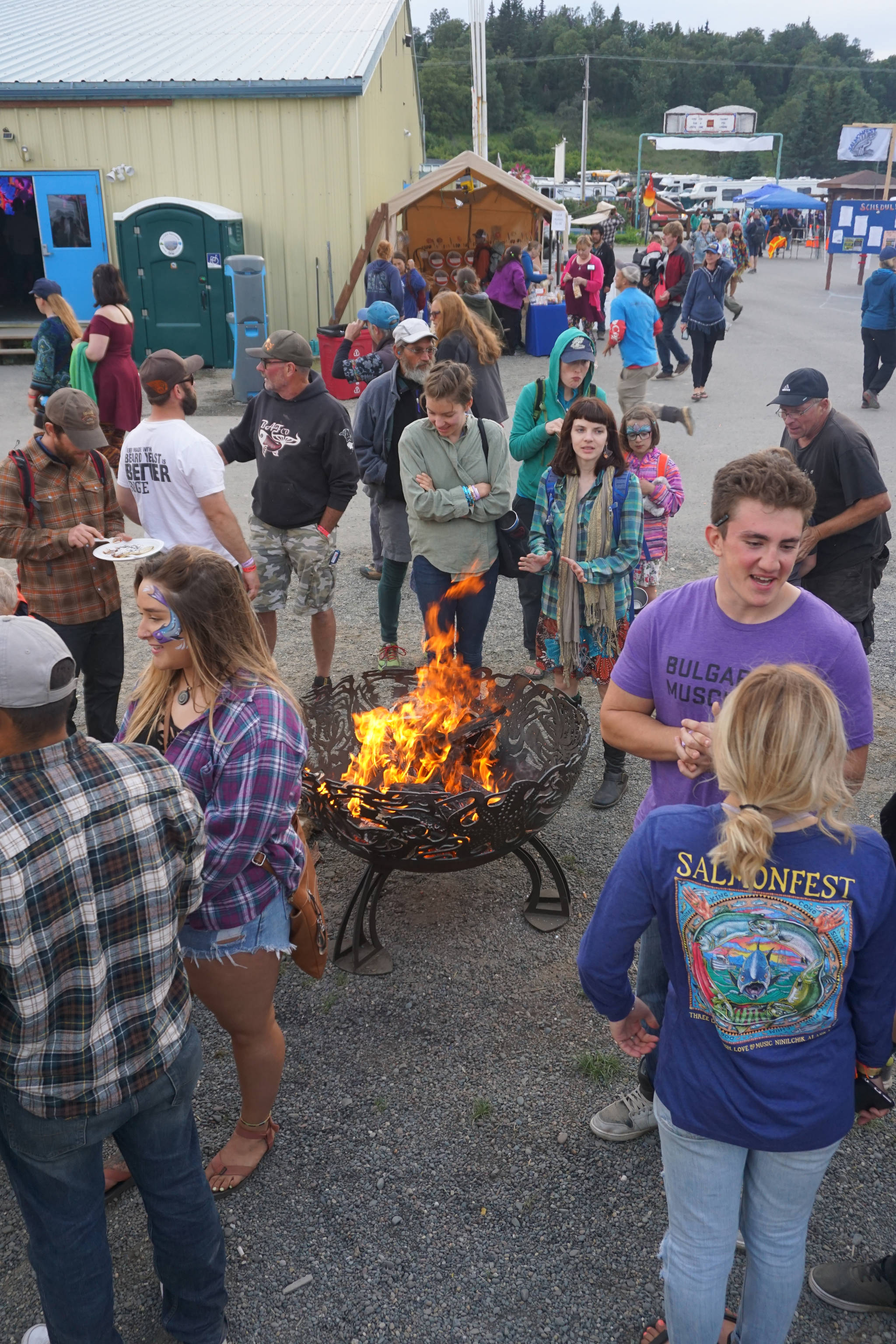 People stand around a fire pit on Saturday night, Aug. 5, 2017, at Salmonfest, Ninilchik, Alaska. (Photo by Michael Armstrong, Homer News)