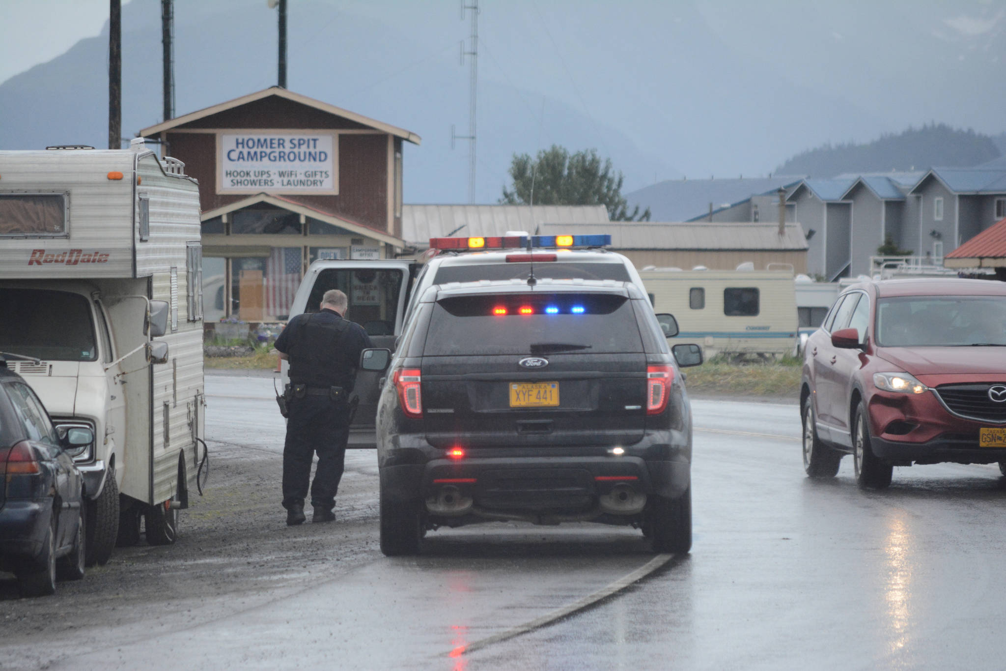 Homer Police Officer Ed Stading puts a 27-year-old California man into a patrol vehicle about 12:30 p.m. Wednesday on the Homer Spit near Fish Dock Road. Police later released the man at the scene. (Photo by Michael Armstrong, Homer News)