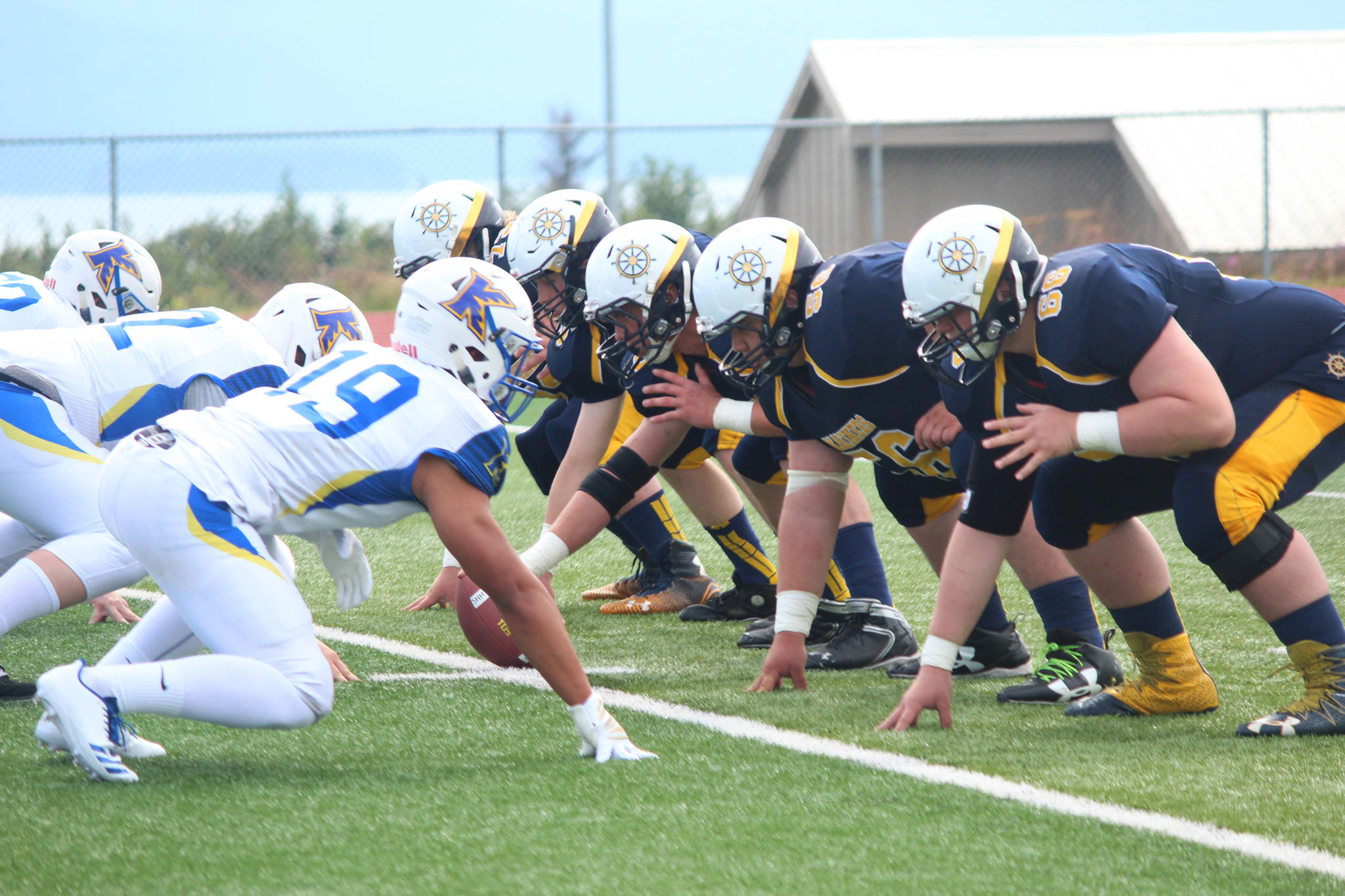 Members of the Homer Mariners varsity football team face off against those from Kodiak High School during their game Saturday, Aug. 12, 2017 at Homer High School in Homer, Alaska. Kodiak defeated the Mariners 21-8. (Photo by Megan Pacer/Homer News)