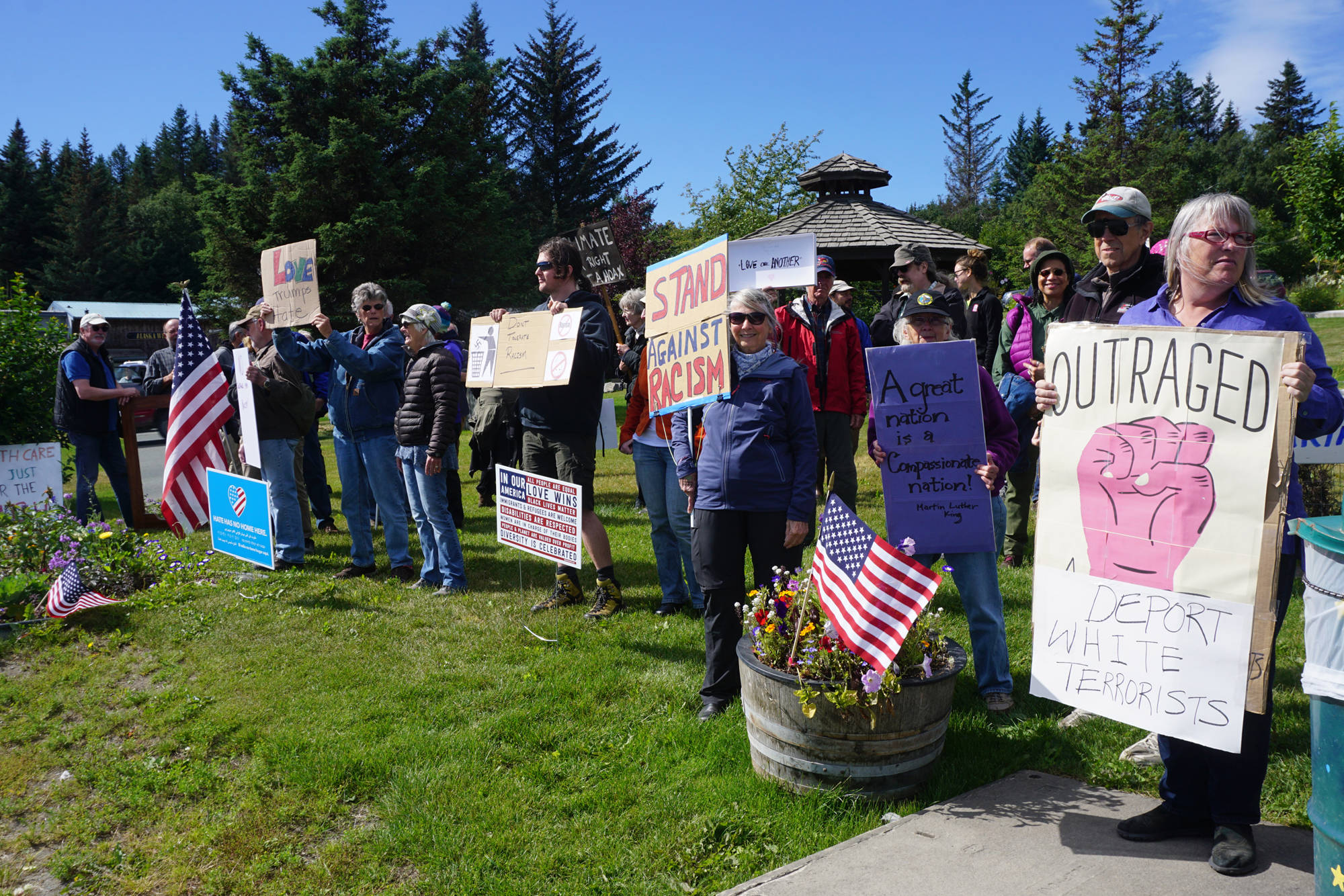 People demonstrating against the events of Charlottesville, Va., and other white supremacist rallies stand up against racism at WKFL Park in Homer on Sunday afternoon. About 50 people attended the one-hour event held from 3-4 p.m. Sunday, Aug. 13, 2017 in Homer, Alaska. (Photo by Michael Armstrong, Homer News)