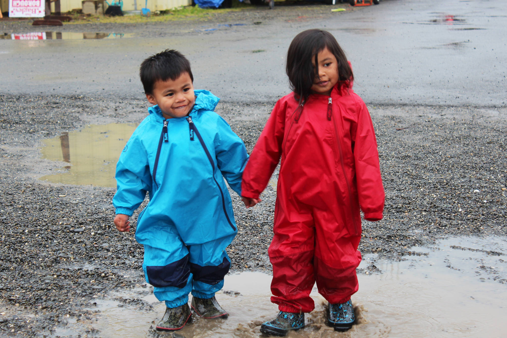 Siblings Everett Malone, 3, and Kaydence Malone, 4, splash around in the puddles spotting the fairgrounds during this year’s Kenai Peninsula Fair on Friday, Aug. 18, 2017 in Ninilchik, Alaska. (Photo by Megan Pacer/Homer News)