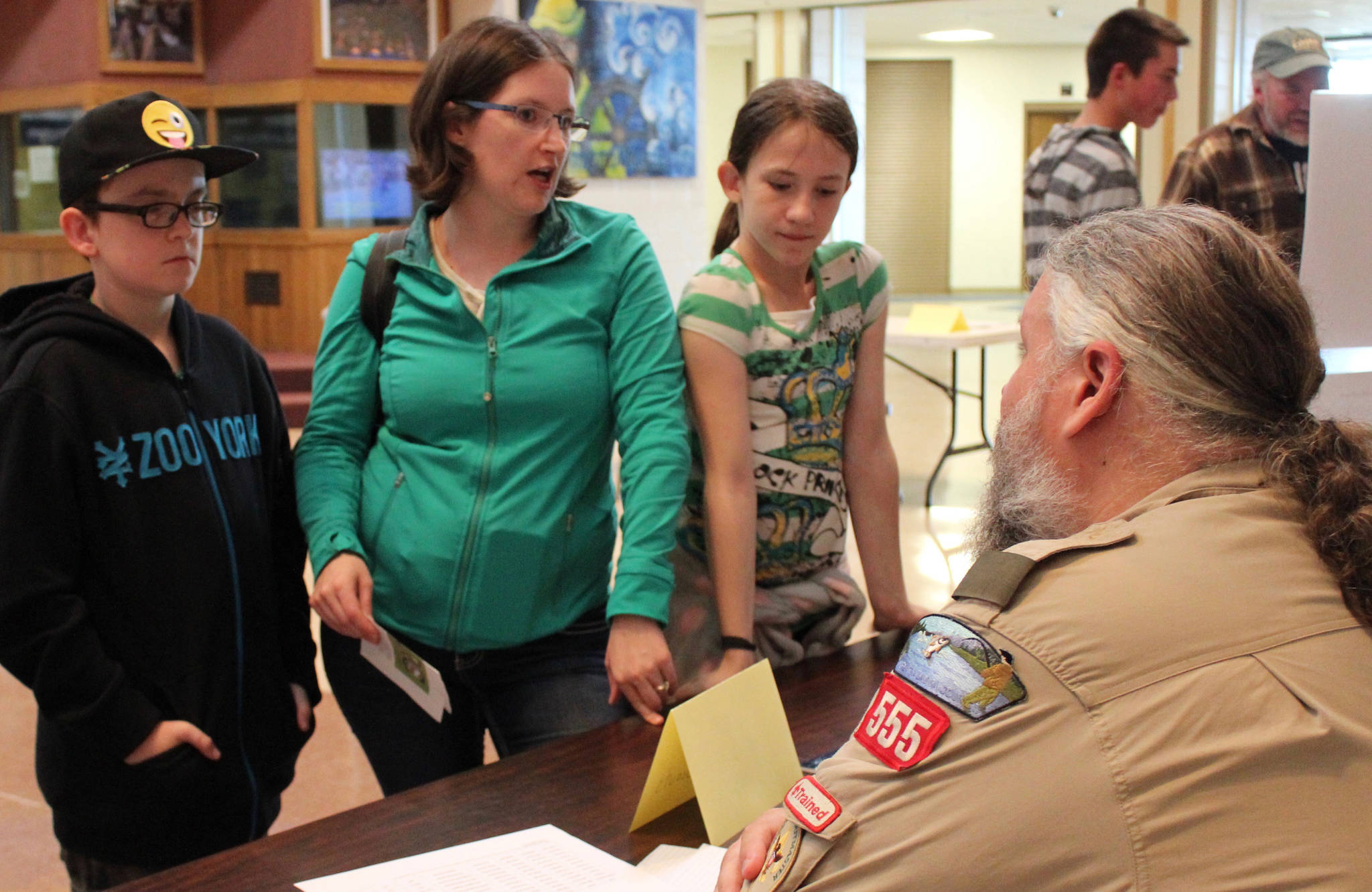 Representing Boy Scouts and Cub Scouts of America, Brian Partridge, seated, discusses after-school activities with (from left) Ethan Lurus, Megan Lurus, and Jasmine Lurus. (Photo by McKibben Jackinsky for the Homer News)