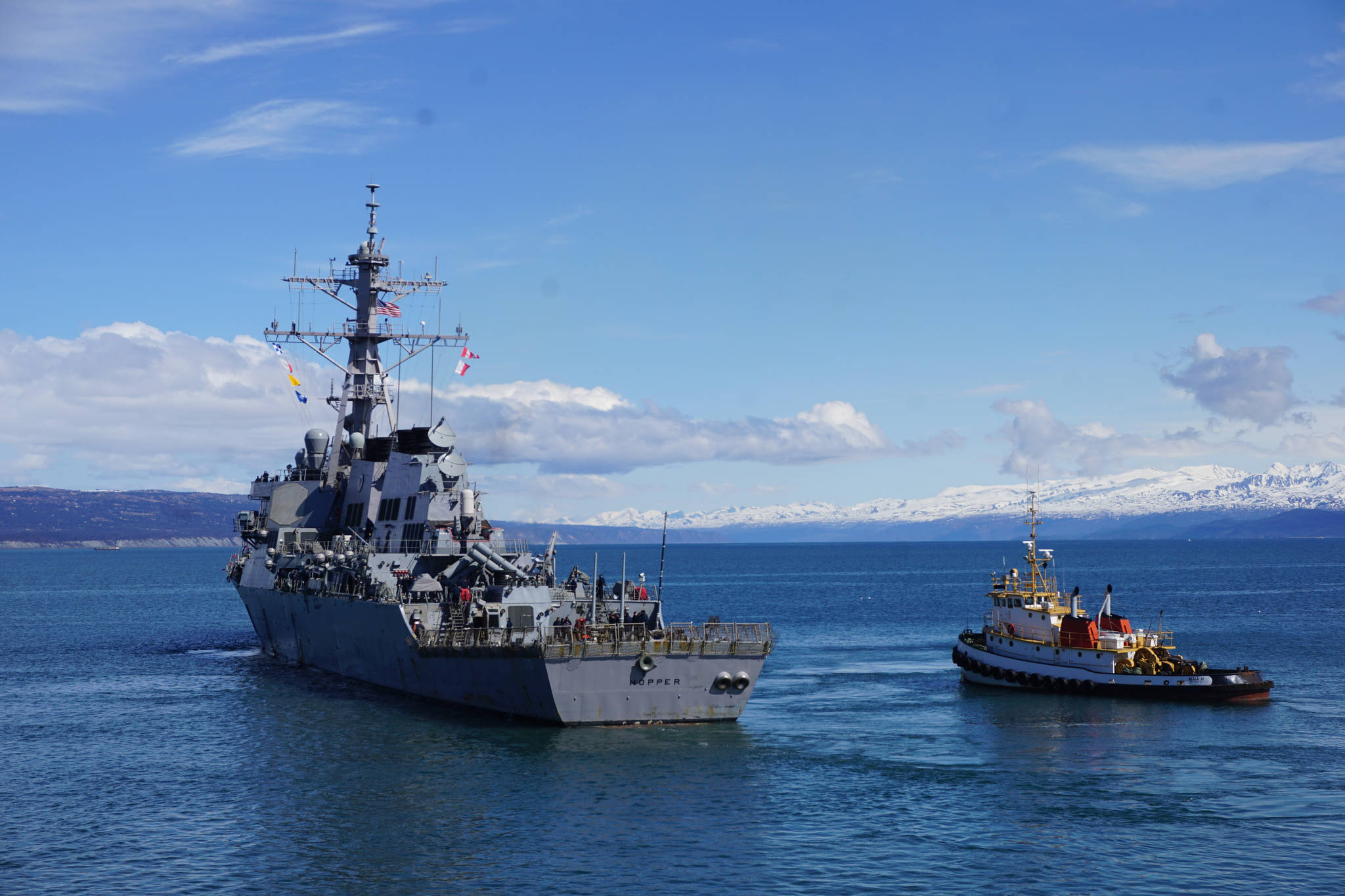 The USS Hopper moves away from the Deep Water Dock on the Homer Spit about noon Saturday, April 29, 2017. A crowd of about 200 people on the beach and another 200 at the dock greeted the Arleigh-Burke class destroyer as it arrived in Alaska. A minus 4.6 low tide at 11:37 a.m. and the wrong dock face prevented Hopper from docking at the Deep Water Dock as planned, and she was to attempt docking later in the afternoon. (Photo by Michael Armstrong/Homer News)