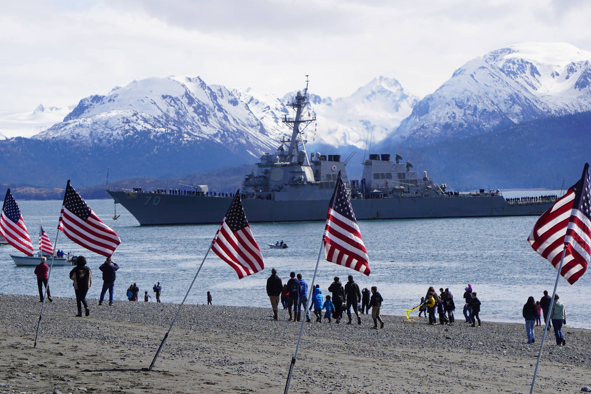 A crowd of about 200 people greeted USS Hopper as she rounded Coal Point at the end of the Homer Spit about noon Saturday, April 29, 2017, as the Arleigh-Burke class destroyer arrived in Alaska. Local veterans groups and the Homer Downtown Rotary Club provided U.S. flags placed on the beach. A minus 4.6 low tide at 11:37 a.m. and the wrong dock face prevented Hopper from docking at the Deep Water Dock as planned, and she was to attempt docking later in the afternoon. (Photo by Michael Armstrong/Homer News)