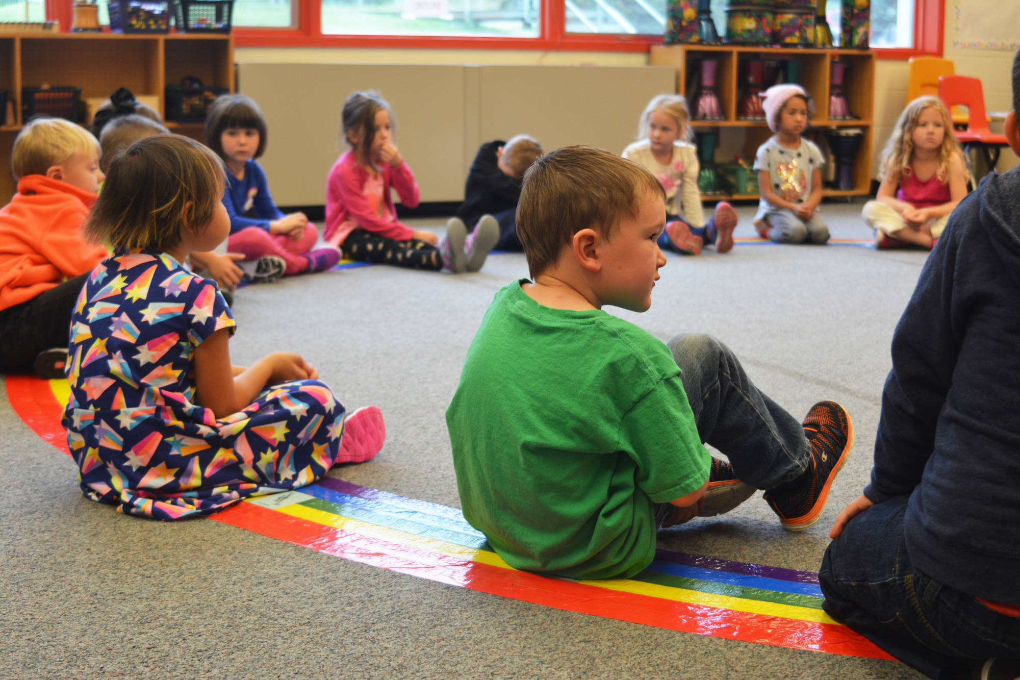 Kindergartener Elijah Ralph glances over at this classmate during a music class on the first day of school Tuesday, Aug. 22, 2017 at Paul Banks Elementary in Homer, Alaska. (Photo by Megan Pacer/Homer News)