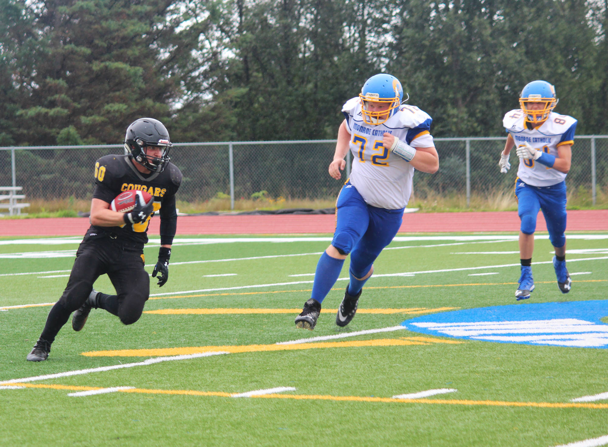 Senior David Sanarov runs the ball for the Voznesenka Cougars during their game against Monroe Catholic High School on Saturday, Aug. 26, 2017 at the Homer Mariners field in Homer, Alaska. The Fairbanks team crushed the Cougars 26-0. (Photo by Megan Pacer/Homer News)