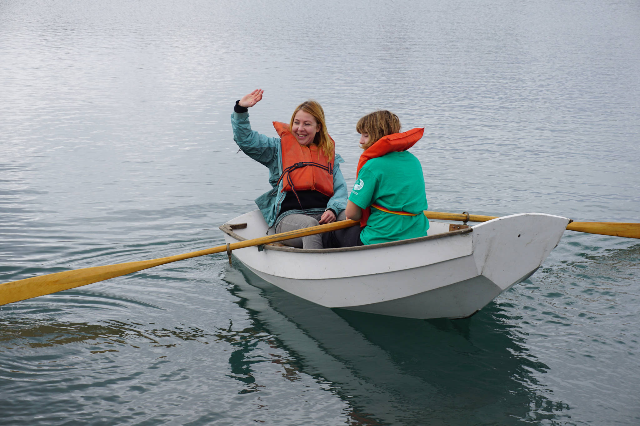 Jenya Anichenko waves as her daughter Tatiana Rogers rows a boat during the Kachemak Bay Wooden Boat Society Festival on Saturday, Sept. 2, 2017 at the Nick Dudiak Fishing Lagoon campground in Homer, Alaska. (Photo by Michael Armstrong, Homer News)