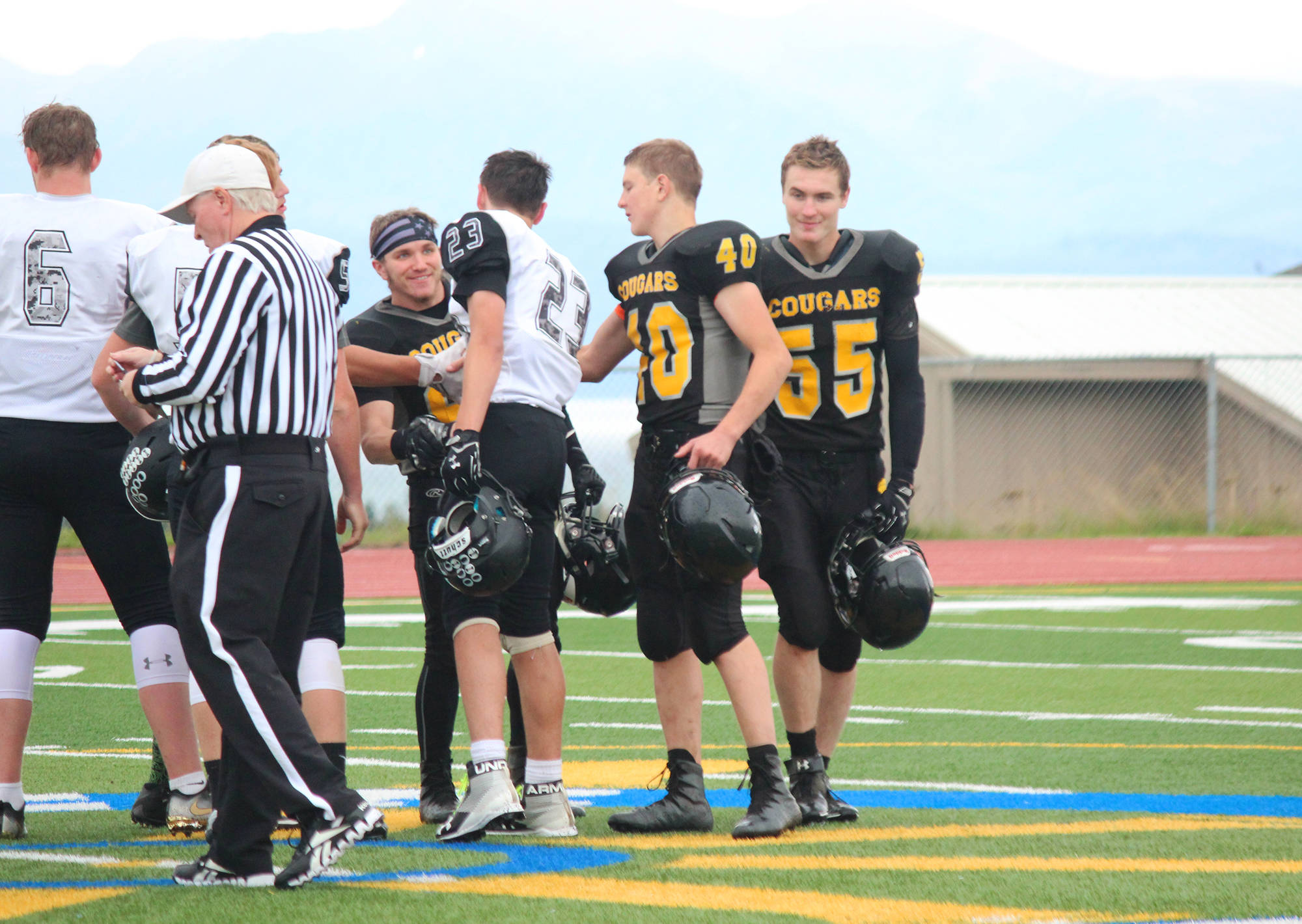 Cougar football players senior David Sanarov, left, sophomore Anthony Kalugin, center, and senior Nikit Anufriev shake hands with captains of the team from Nikiski before their game Saturday, Sept. 2, 2017 in Homer, Alaska. The Cougars lost 18-40 in their second game of the season. (Photo by Megan Pacer/Homer News)