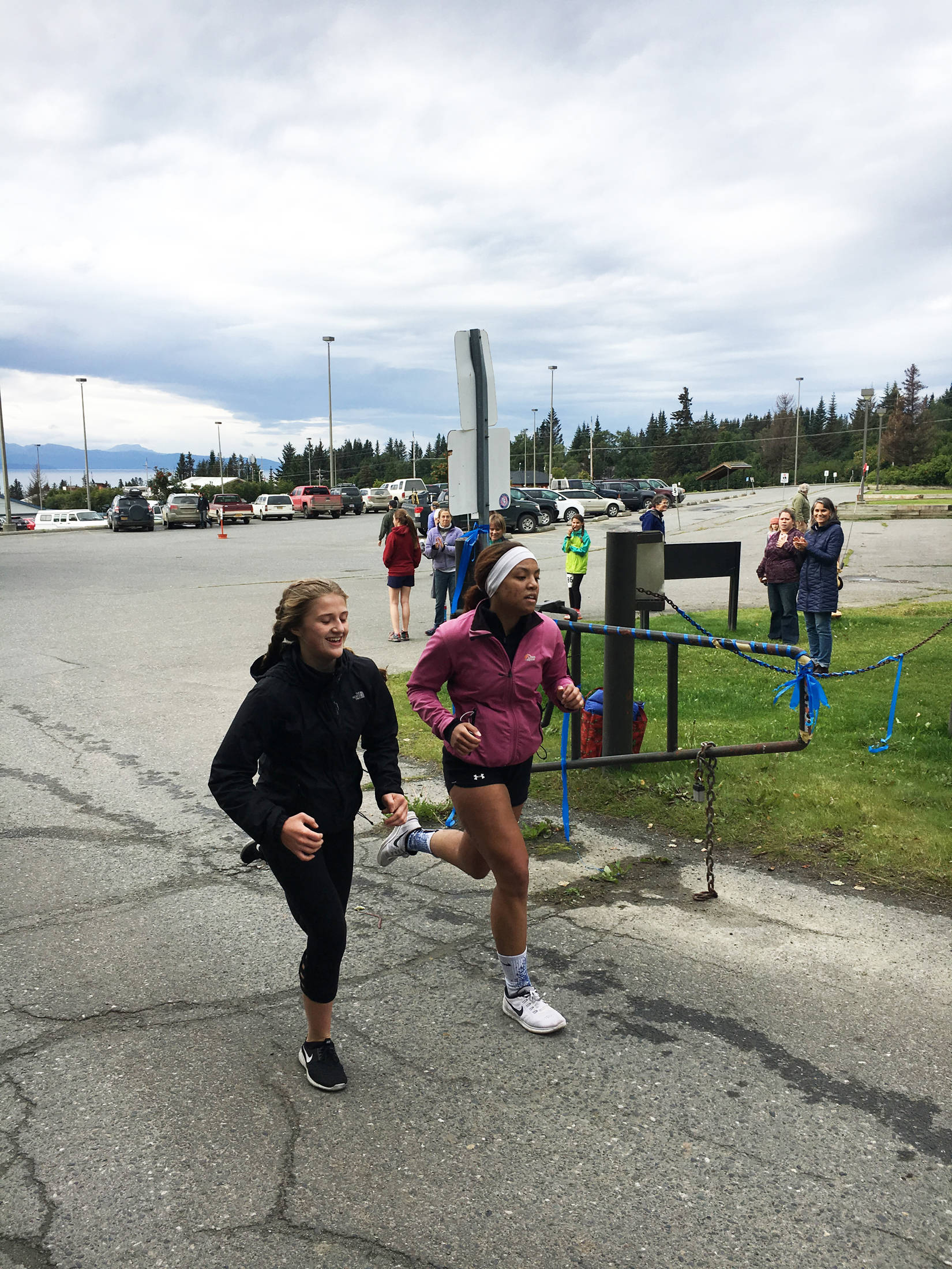 Homer Mariner swimmers Adeline Berry, left and Alia Bales cross the finish line of the Homer Mariner Triathlon on Saturday, Sept. 2, 2017 at the high school in Homer, Alaska. The two tied for fourth place in the 13-17 age group. (Photo courtesy Paul Story)