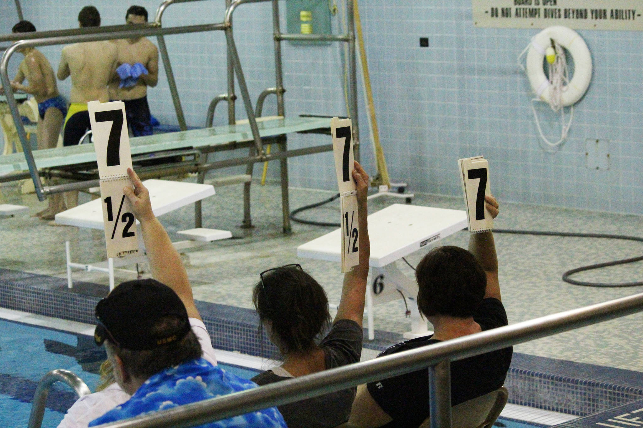Judges hold up their scores during the diving portion of the Homer Invitational on Friday, Sept. 8, 2017 at the Kate Kuhns Aquatic Center in Homer, Alaska. (Photo by Megan Pacer/Homer News)
