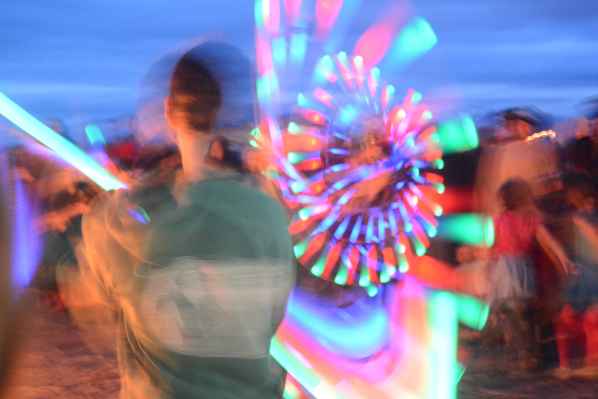Revelers spin LED lighted poi at Shine, the 2017 Burning Basket, as it burns on Sunday, Sept. 10, 2017 at Mariner Park on the Homer Spit. (Photo by Michael Armstrong, Homer News)