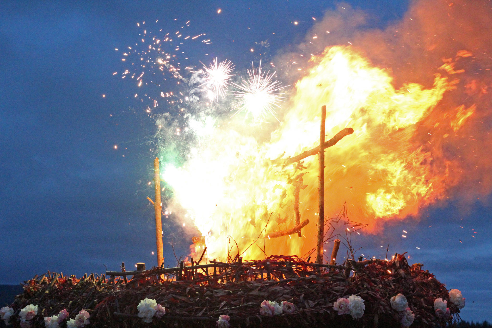 Fireworks explode on top of this year’s Burning Basket Project while it burns in a celebratory ceremony Sunday, Sept. 10, 2017 at Mariner Park in Homer, Alaska. This year’s theme for the basket was “Shine.” (Photo by Megan Pacer/Homer News)