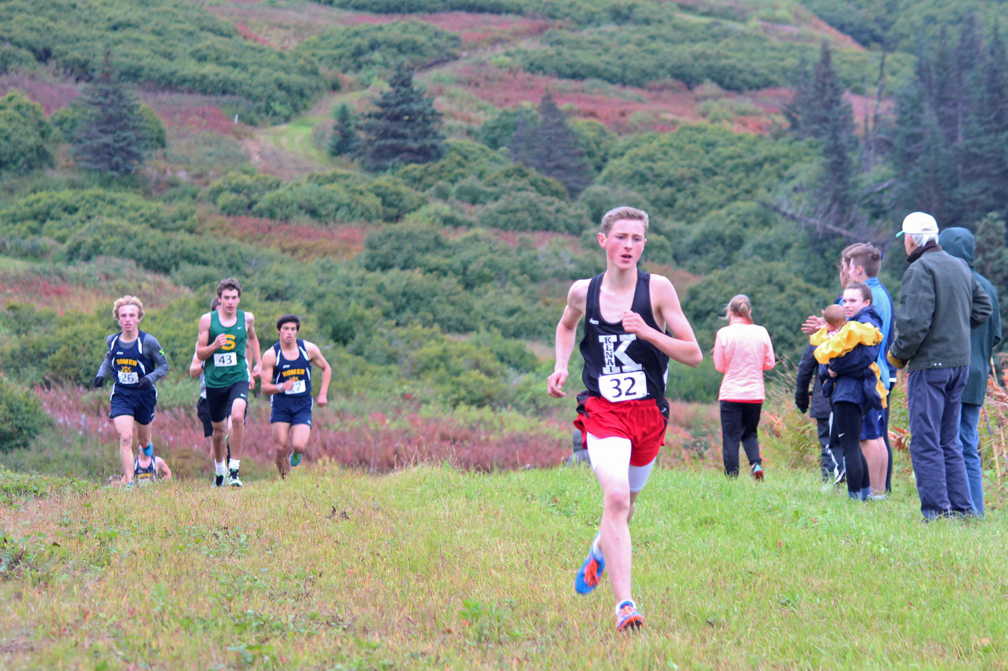 Kenai Central High School runner Maison Dunham pulls ahead of the pack nearing the end of the varsity boys race at the Kenai Peninsula Borough Cross Country Running Championships on Tuesday, Sept. 12, 2017 at the Lookout Mountain Trails near Homer, Alaska. Soldotna High School took first overall out of the varsity boys teams, and the Kenai team claimed the top spot for the girls. (Photo by Megan Pacer/Homer News)
