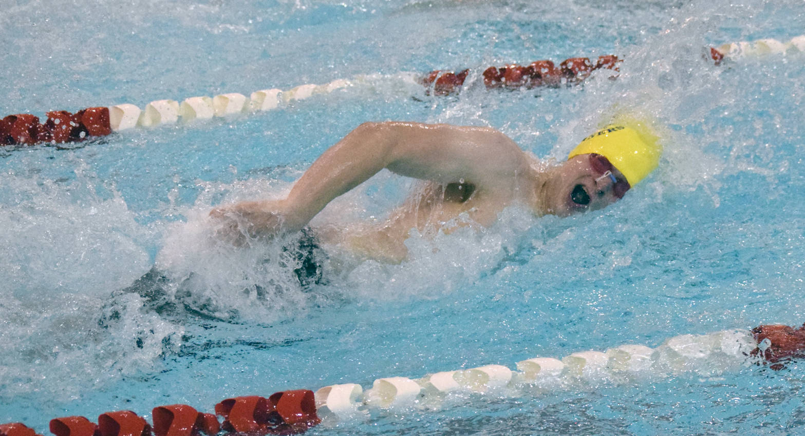 Homer’s Clayton Arndt swims to second place in the 100 freestyle Saturday, Sept. 16, 2017, at the Kenai Invitational at Kenai Central High School. (Photo by Jeff Helminiak/Peninsula Clarion)