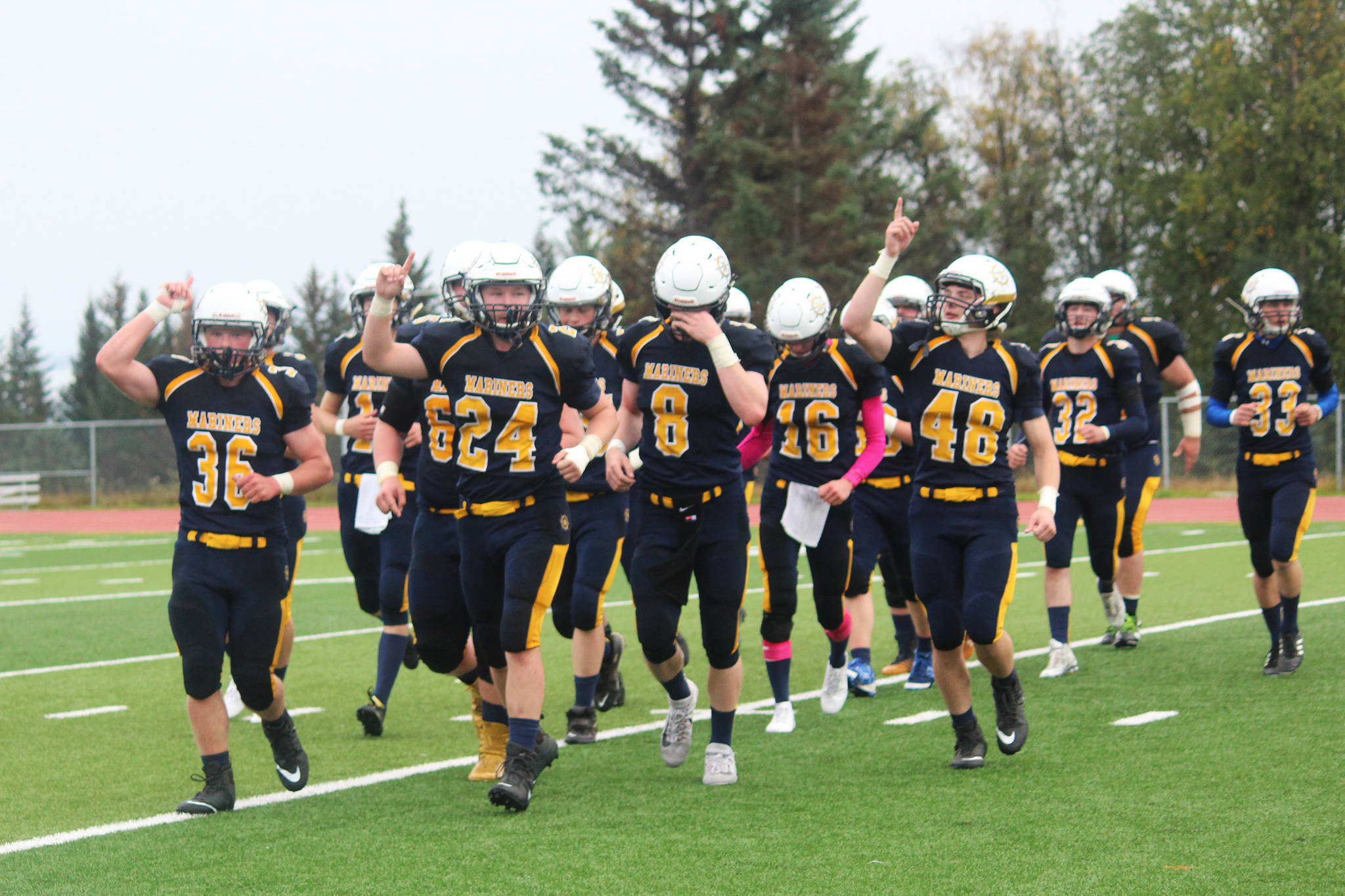 Players on the Homer Mariners varsity football team leave the field celebrating after their win against Nikiski High School in a homecoming game Saturday, Sept. 16, 2017 at Homer High School in Homer, Alaska. The Mariners topped the Bulldogs 38-0. (Photo by Megan Pacer/Homer News)