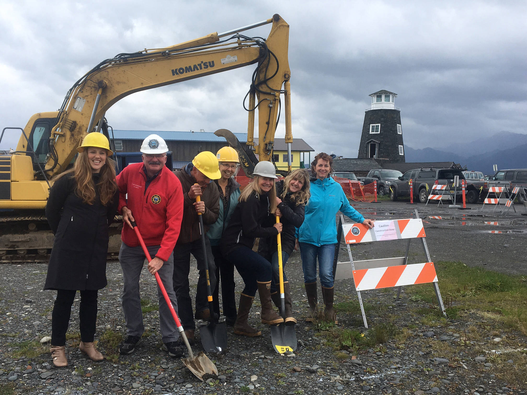 From left to right, Katie Koester, Bryan Hawkins, Gart Curtis, Joy Stewart, Polly Hess, Miranda Weiss and Denise Pitzman break ground on Sept. 6 for the start of The Boat House Maritime Pavillion on the Homer Spit at the site of the old harbormaster’s office. The concrete foundation already has been poured, Most work will be done this fall. (Photo provided)