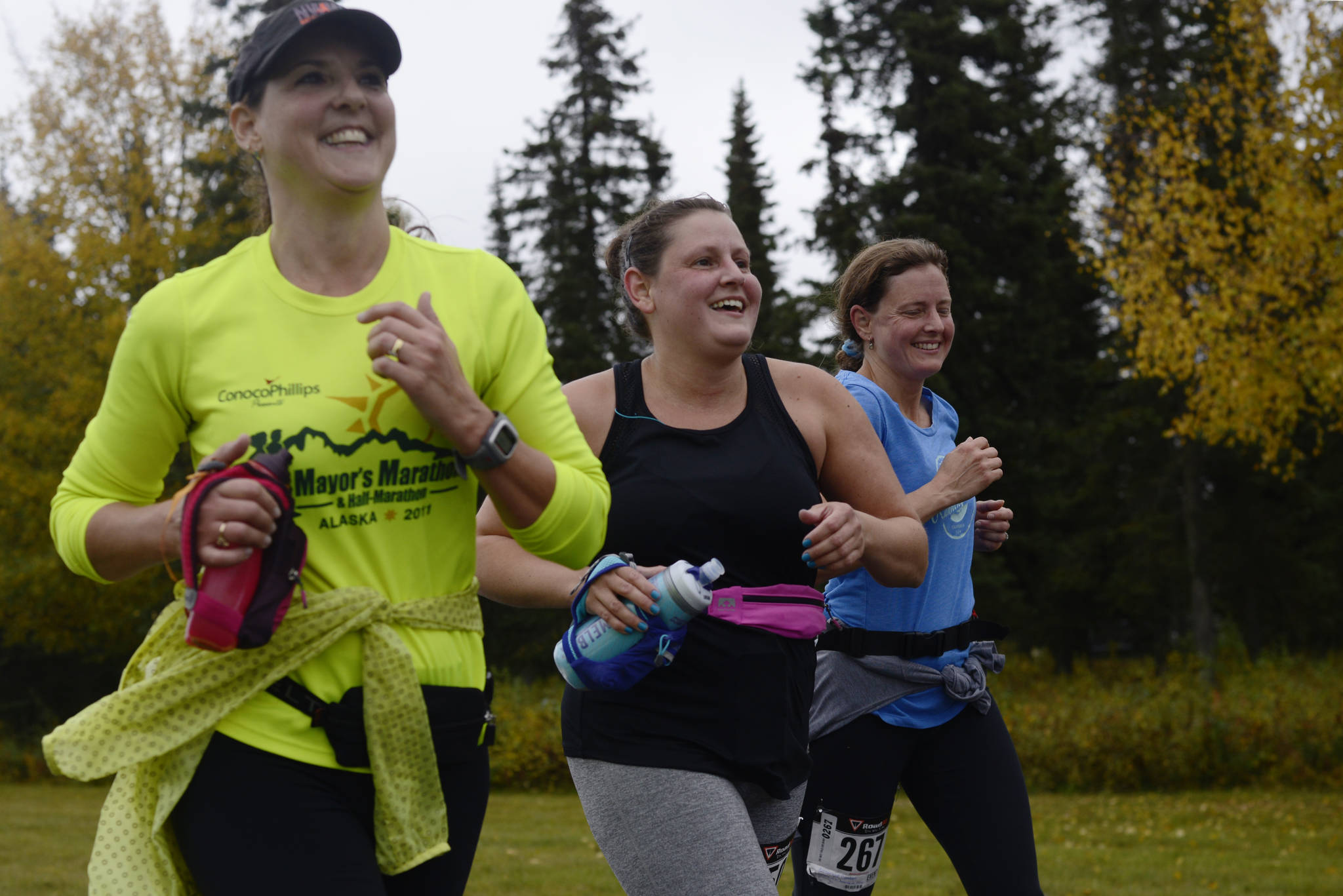 Runners Kimberly Buskirk (left), Kate Swaby, and Candace Cartwright run in the Kenai River half-marathon on Sunday, Sept. 24, 2017 in Kenai, Alaska. (Photo by Ben Boettger/Peninsula Clarion)
