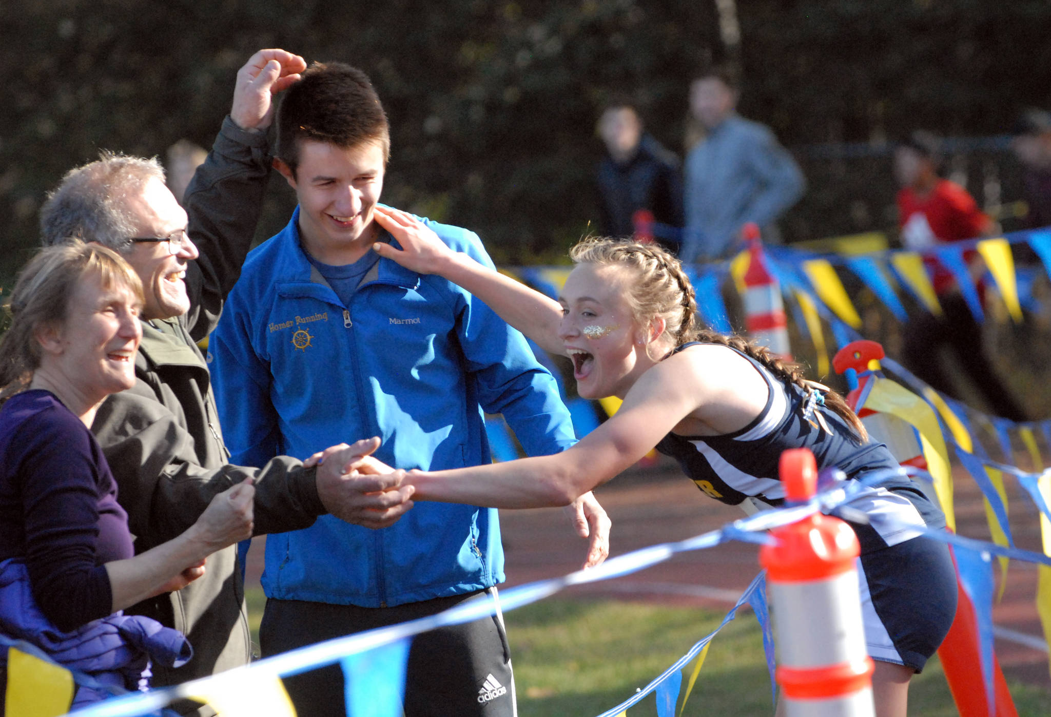 Homer freshman Autumn Daigle celebrates her victory in the Division II girls race with her mom, Anne, dad, Patrick, and teammate Jordan Beachy at the ASAA/First National Bank Alaska State Cross Country Championships on Saturday, Sept. 30, 2017 at Bartlett High School in Anchorage, Alaska. (Photo by Matt Tunseth/Chugiak-Eagle River Star)