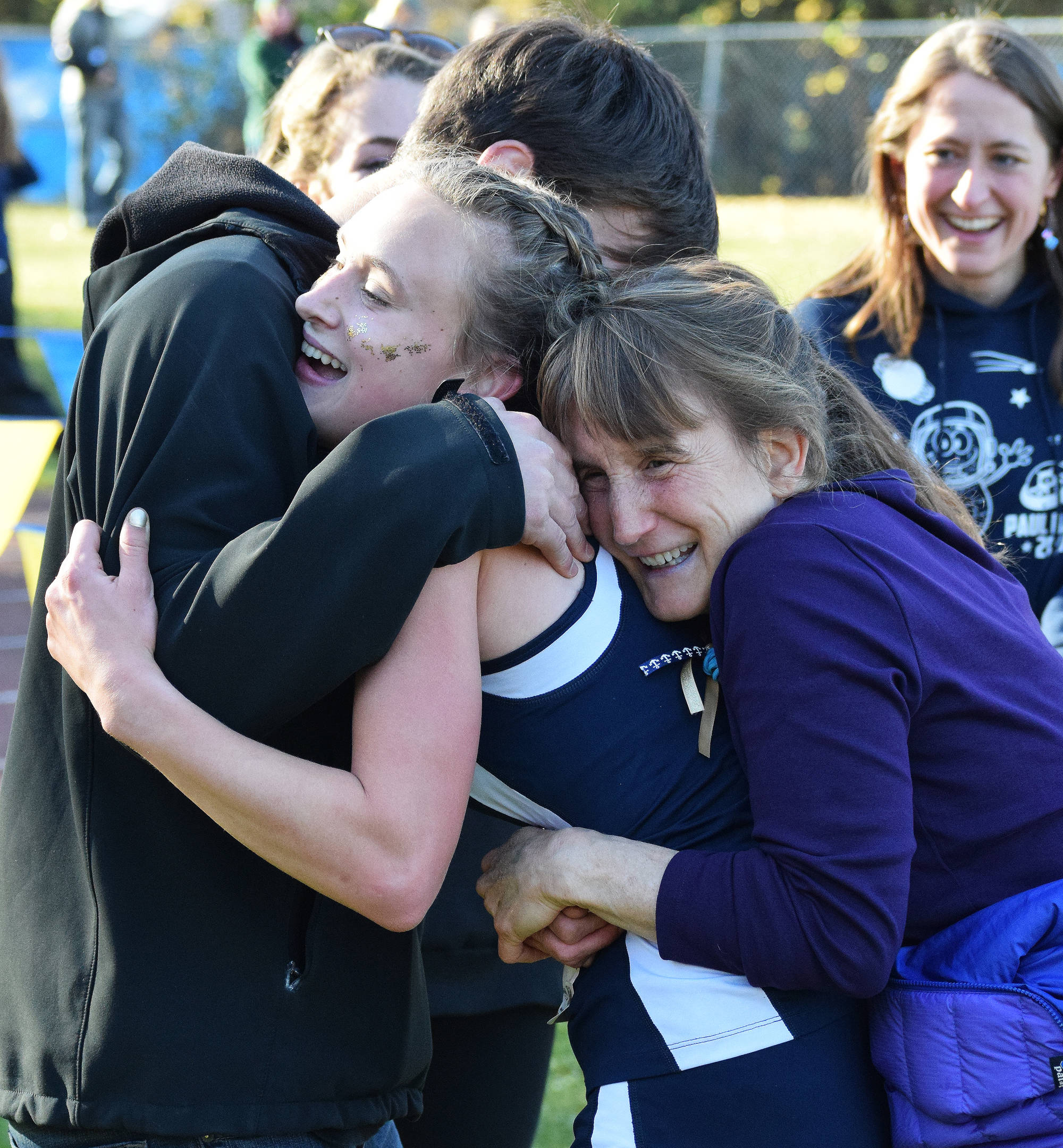 Division II girls winner Autumn Daigle (center) receives hugs from her brother and mother Ann (right) Saturday, Sept. 30, 2017 at the ASAA First National Bank Alaska Cross-country State Championships at Bartlett High School in Anchorage, Alaska. (Photo by Joey Klecka/Peninsula Clarion)