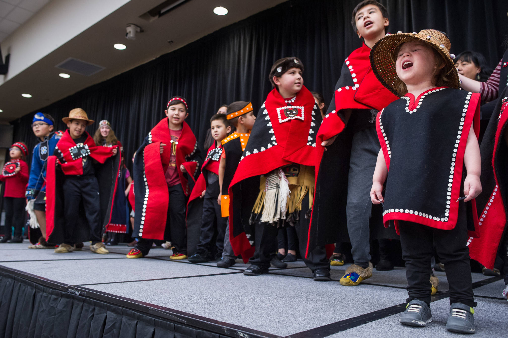 Natalie Soto, 2, helps sing with the All Nations Children Dancers as Juneau residents celebrate Indigenous Peoples Day at Elizabeth Peratrovich Hall on Monday, Oct. 9, 2017. (Michael Penn