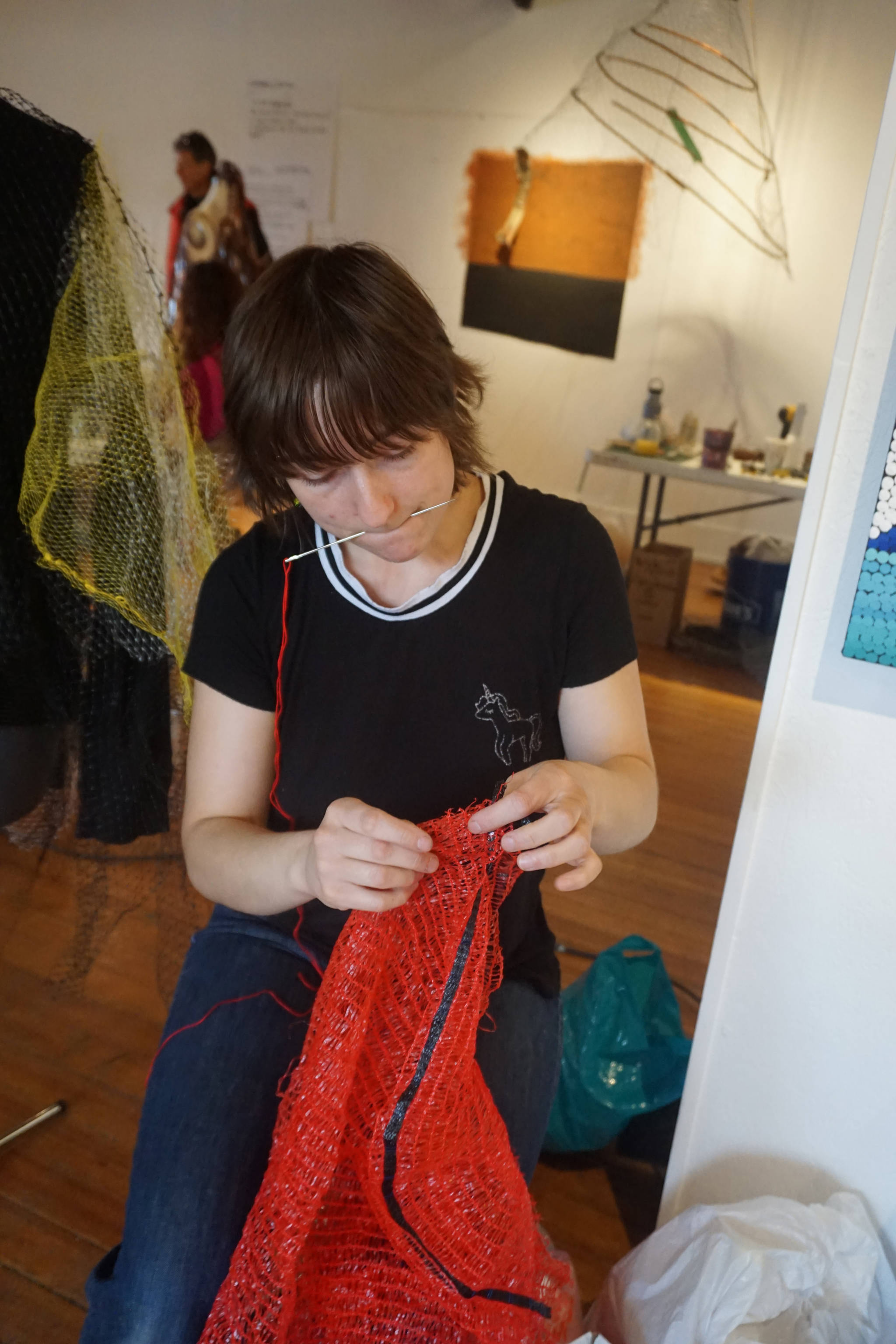 Mallory Drover works on a Wearable Arts piece Saturday, Oct. 14, 2017 at a workshop with Sheila Wyne at the Bunnell Street Arts Center in Homer, Alaska. She tore apart fruit bags as dress material. Drover is a Homer student and a visual arts major attending Antioch College, Yellow Springs, Ohio. She took Wyne’s workshop as part of work study at Antioch. (Photo by Michael Armstrong)