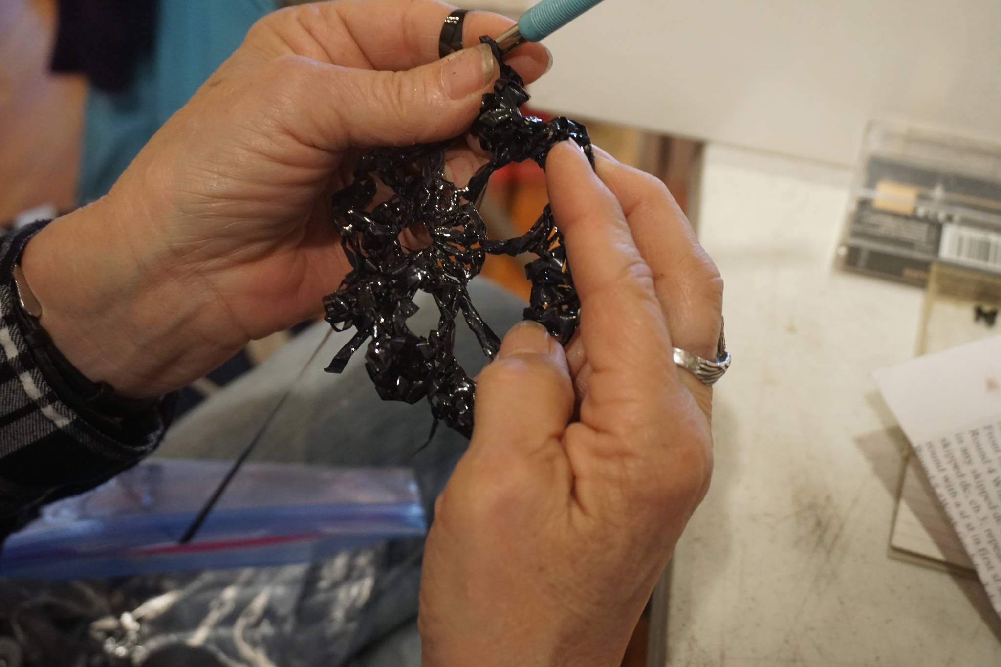 Linda Robinson crochets cassette tape film into flowers for a Wearable Arts piece Saturday, Oct. 14, 2017 at a workshop with Sheila Wyne at Bunnell Street Arts Center in Homer, Alaska. (Photo by Michael Armstrong)