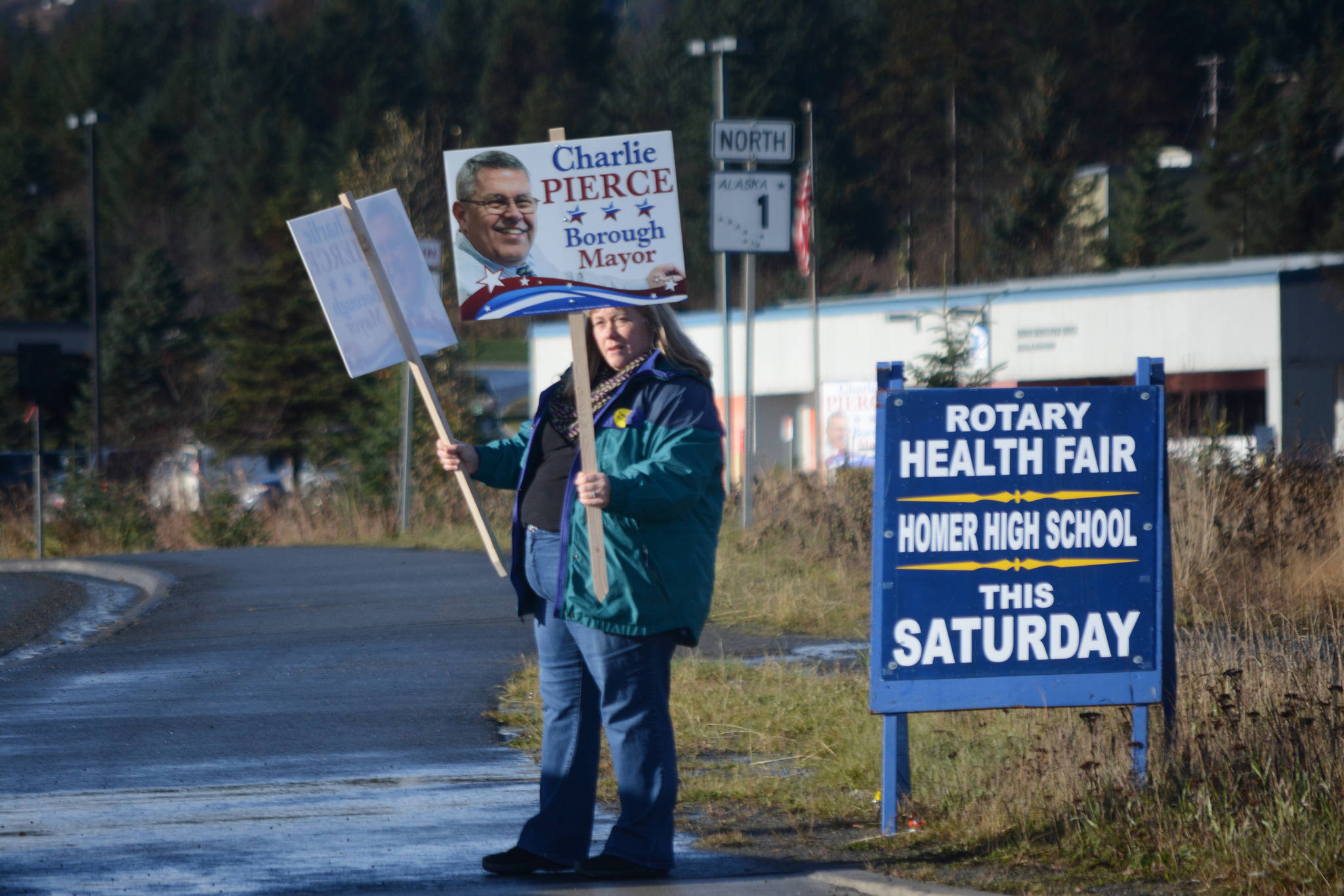 Lou Pontious waves signs for Charlie Pierce on Tuesday afternon, Oct. 24, 2017, in Homer, Alaska, on the Homer Bypass near Lake Street. (Photo by Michael Armstrong, Homer News)