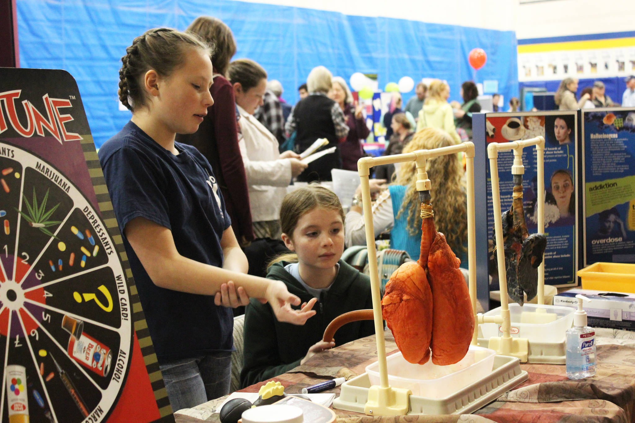 Taylor Rickard, left, and Archer Matysczak, right, educate passersby about the dangers of smoking at their booth from the Ninilchik Village Tribe at the Rotary Health Fair on Saturday, Oct. 28, 2017 at Homer High School in Homer, Alaska. (Photo by Megan Pacer/Homer News)