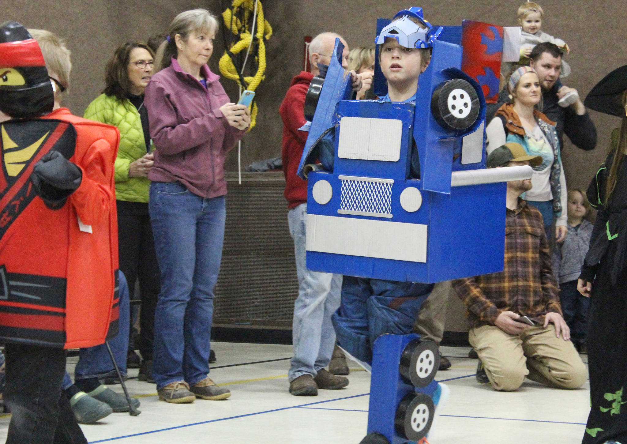 Fletcher Darr, an elementary student, walks in a Halloween costume parade as a transformer Tuesday, Oct. 31, 2017 at Paul Banks Elementary School in Homer, Alaska. (Photo by Megan Pacer/Homer News)