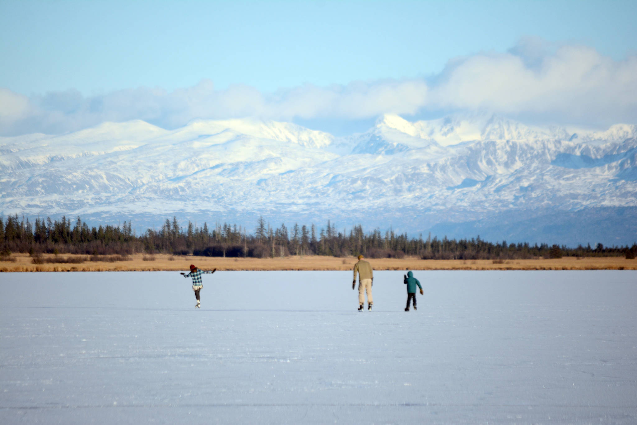 Skaters glide across Beluga Lake last Friday afternoon, Nov. 17, 2017 in Homer, Alaska. With clear and cold weather, the lake has frozen enough to support ice skating. A slight dusting of snow last Thursday didn’t affect skating. (Photo by Michael Armstrong, Homer News)