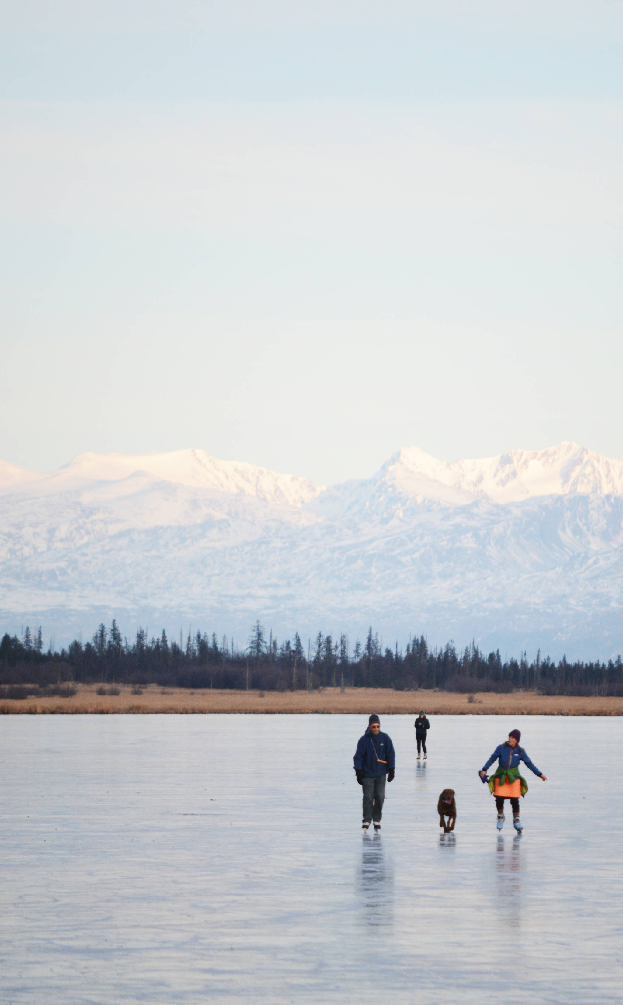 Skaters glide across Beluga Lake last Wednesday afternoon, Nov. 15, 2017 in Homer, Alaska. With clear and cold weather, the lake has frozen enough to support ice skating. A slight dusting of snow last Thursday didn’t affect skating. (Photo by Michael Armstrong, Homer News)