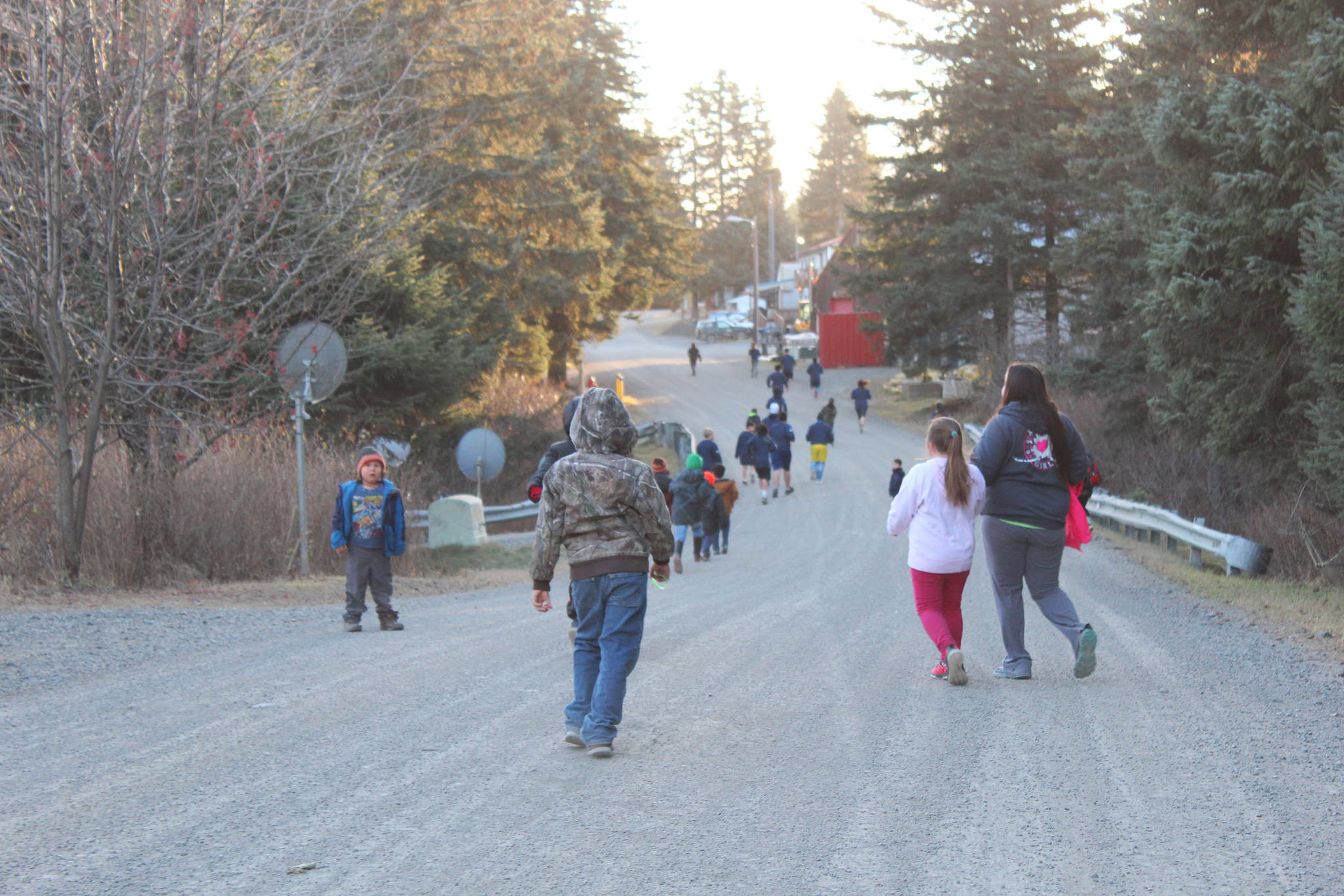 Students and faculty from Port Graham School run through the village as part of a presentation by visiting human rights lawyer Chris Mburu, who works for the United Nations, and Kimani Nyambura on Thursday, Nov. 16, 2017 in Port Graham, Alaska. The pair visited and spoke to several Kenai Peninsula schools on Nov. 16-17 about their journey through education from a small village in Kenya and Mburu’s creation of a foundation to help Kenyan children go to school. (Photo by Megan Pacer/Homer News)