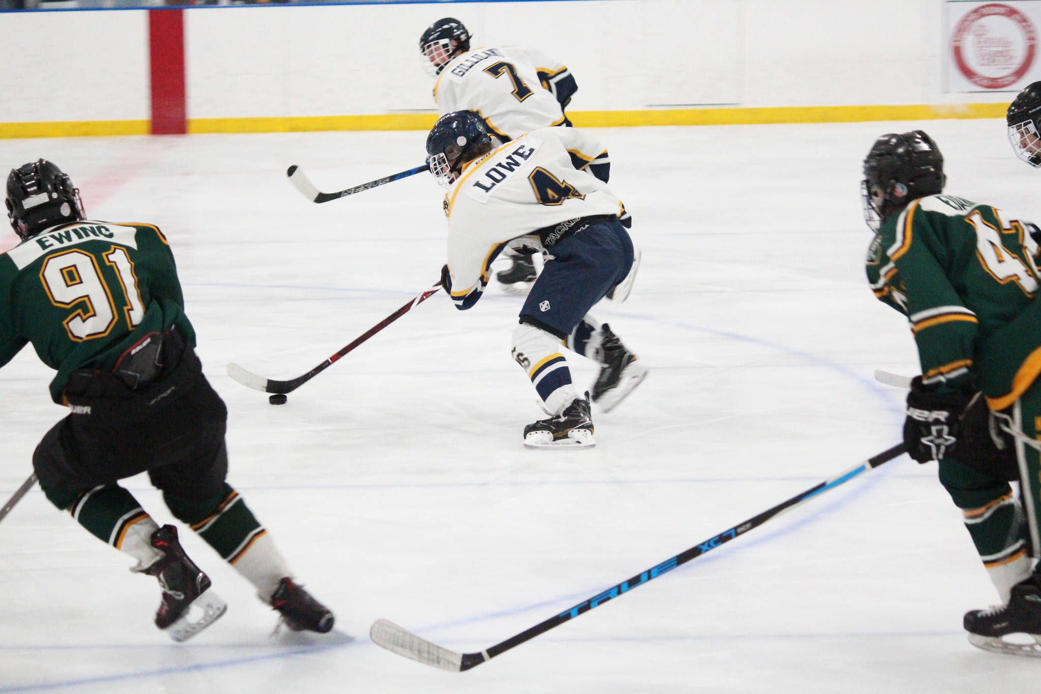 Homer’s Lee Lowe skates with the puck, pursued by several Colony High School players, during their hockey game Friday, Dec. 1, 2017 at Kevin Bell Arena in Homer, Alaska. The Mariners beat Colony 2-1, and swept the Mat-Su Valley teams over the weekend, winning all three of their games. (Photo by Megan Pacer/Homer News)