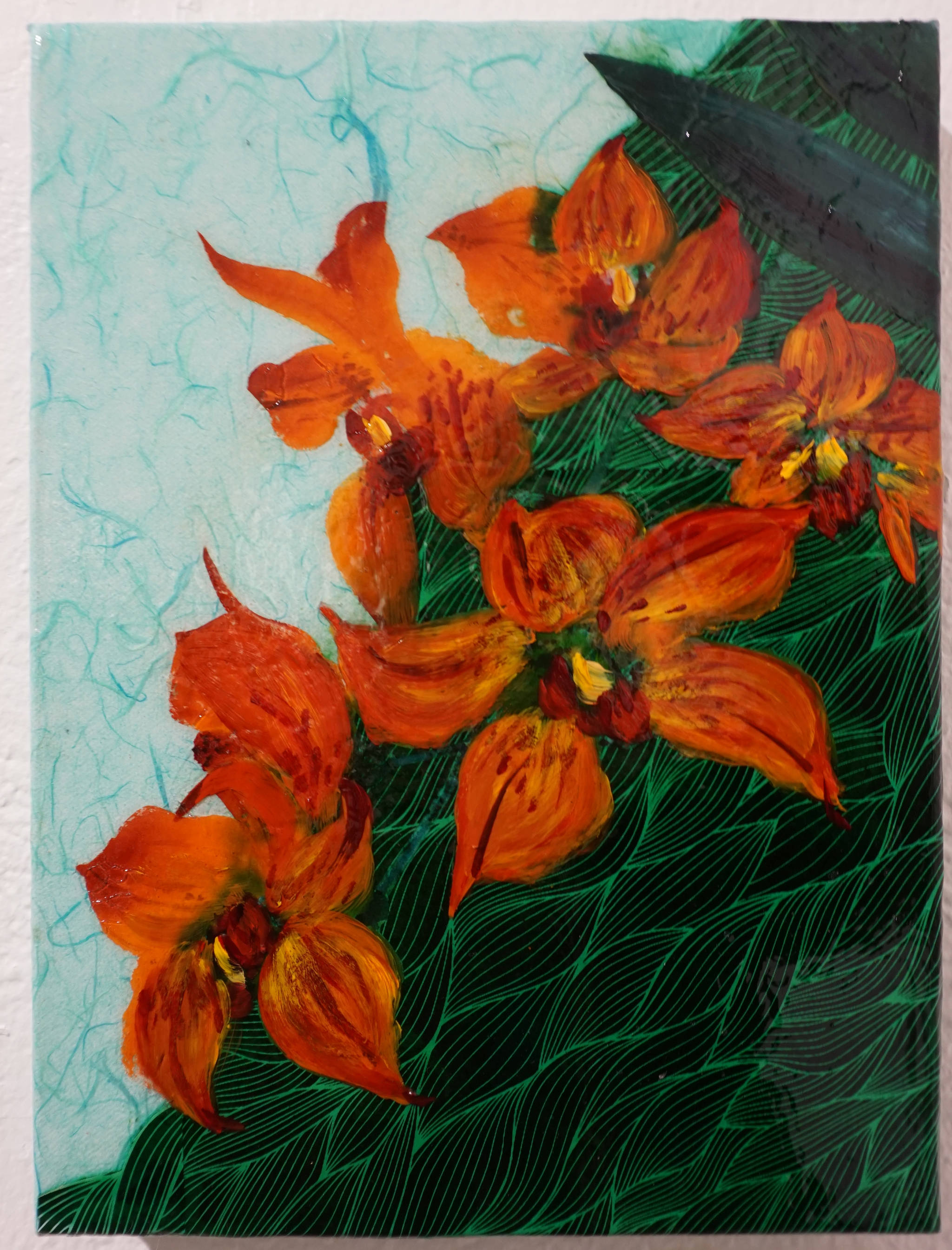 “Orange Orchid,” one of Sharlene Cline’s collages of a Chinese brush painting and other media, shown here Friday, Dec. 1, 2017 at Ptarmigan Arts in Homer, Alaska. (Photo by Michael Armstrong, Homer News)