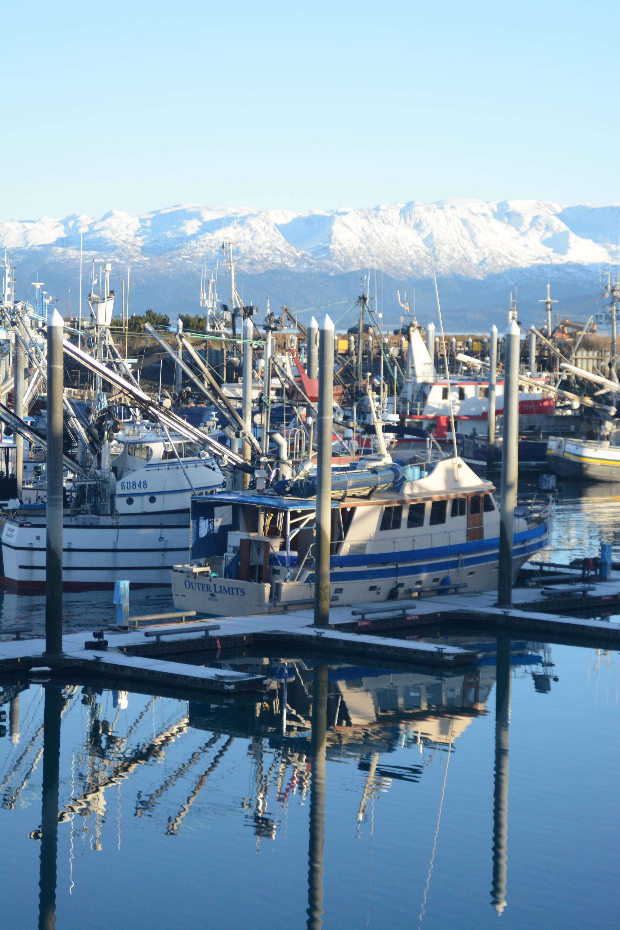 Boats are reflected in smooth waters at the Homer Harbor onFriday, Dec. 8, 2017 in Homer, Alaska — a rare sunny day during a month that has otherwise been cloudy and wet. (Photo by Michael Armstrong, Homer News)