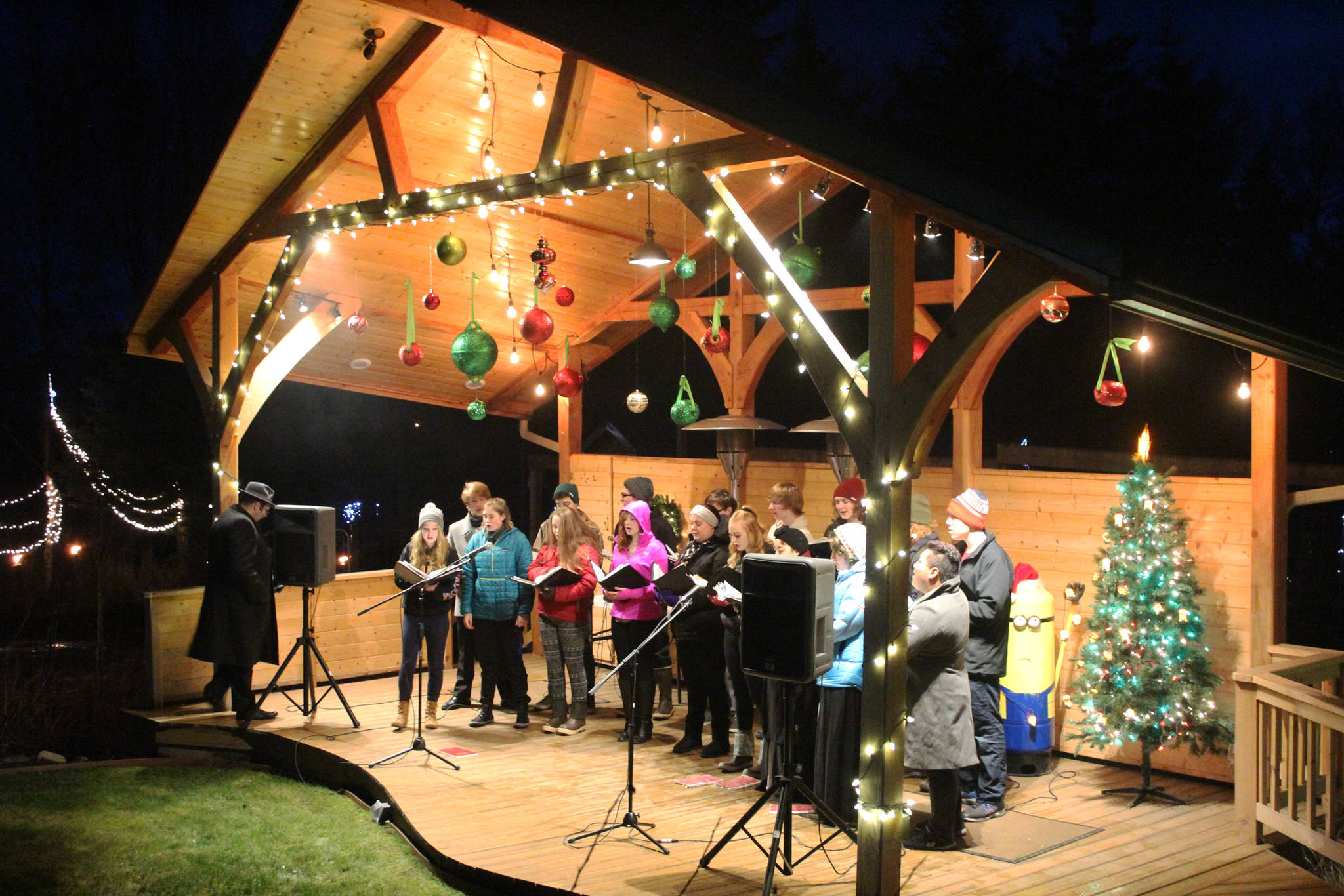 Members of the Homer High School Swing Choir serenade passersby from a pavilion on the Bear Creek Winery Gardens on Saturday, Dec. 16, 2017 near Homer, Alaska. The business hosts each year the Bear Creek Winery Garden of Lights, which feature a lighted evening walk through the gardens, which are decked out with holiday lights and structures. (Photo by Megan Pacer/Homer News)