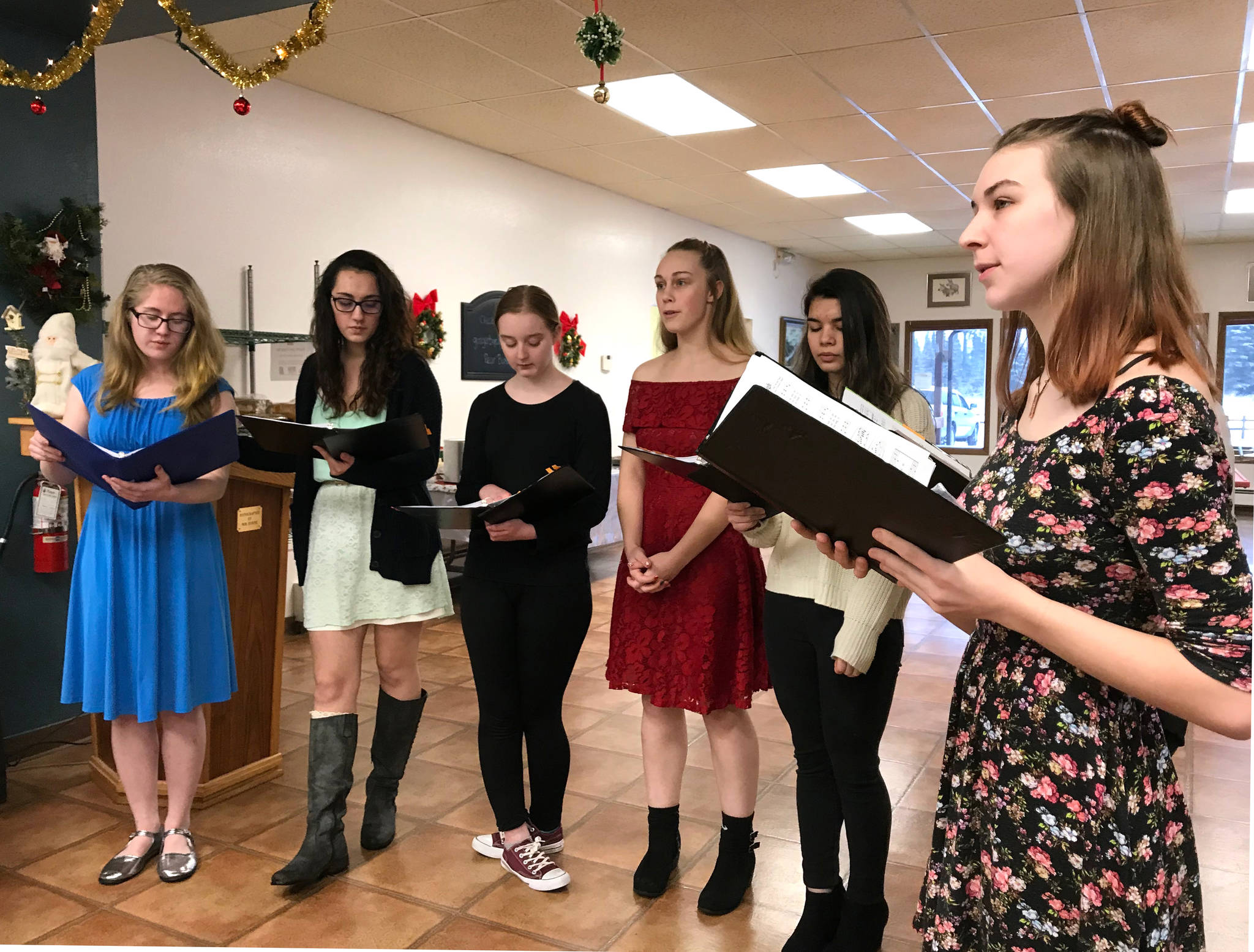 A group of students from Ninilchik School sing Christmas carols at the Ninilchik Senior Center on Tuesday, Dec. 19, 2017. The students practice during their free period since elementary and middle school choir is no longer offered at Ninilchik School. (Photo by Kat Sorensen/Peninsula Clarion)