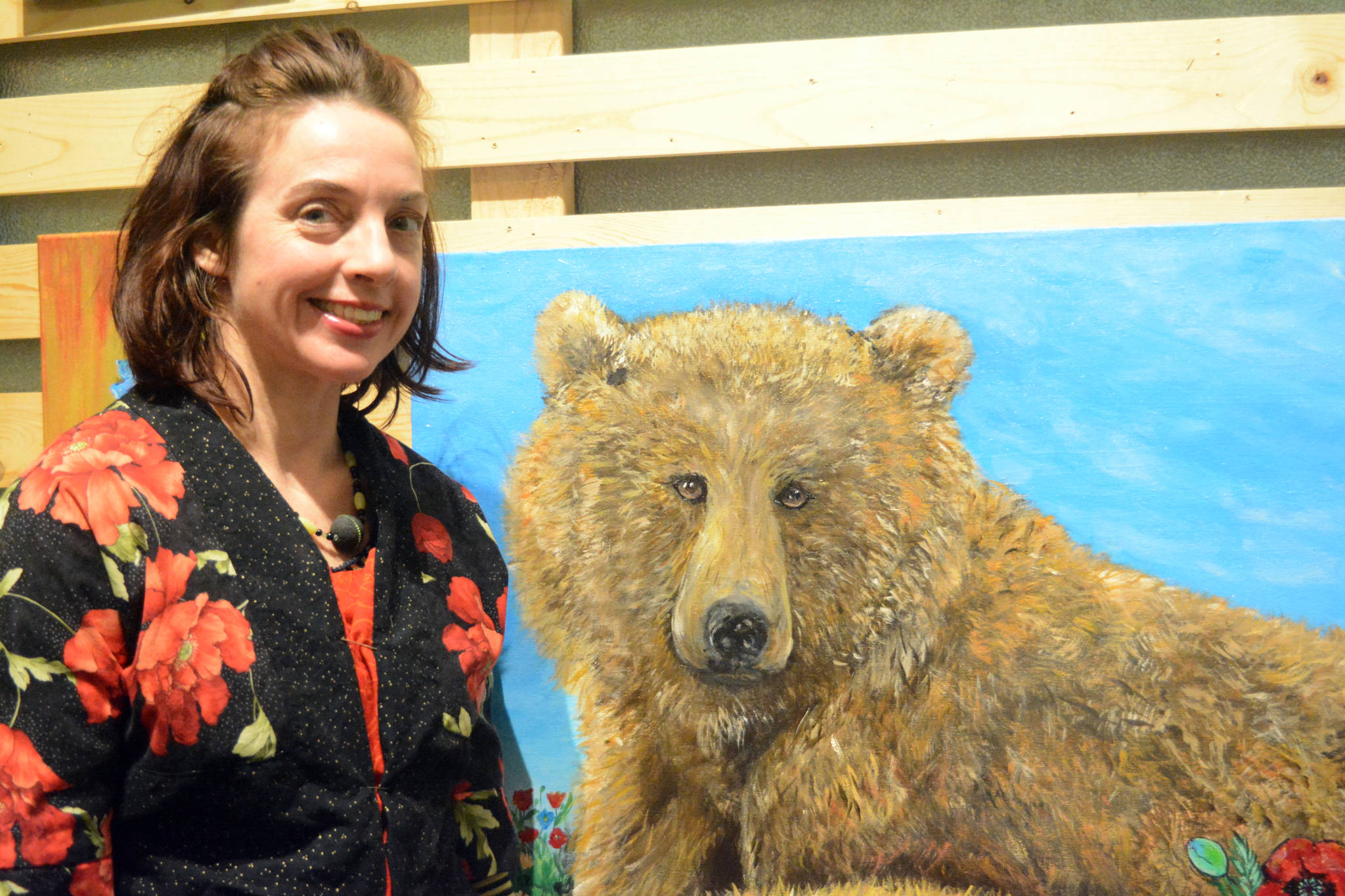 Artist Julianne Tomich stands next to one of her bear paintings at the First Friday opening of her show at Grace Ridge Brewery. (Photo by Michael Armstrong, Homer News)