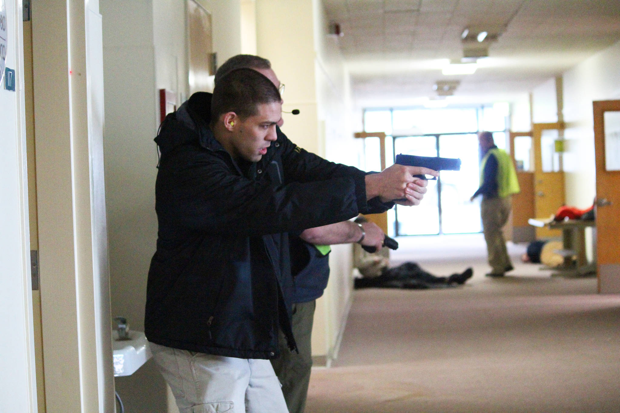 Volunteer Jason Palec holds a fake gun at the ready just before the start of an active shooter simulation Friday, Jan. 12, 2018 at the HERC building in Homer, Alaska. Several drills were run Friday to help police officers and first responders practice addressing emergencies in unison. (Photo by Megan Pacer/Homer News)