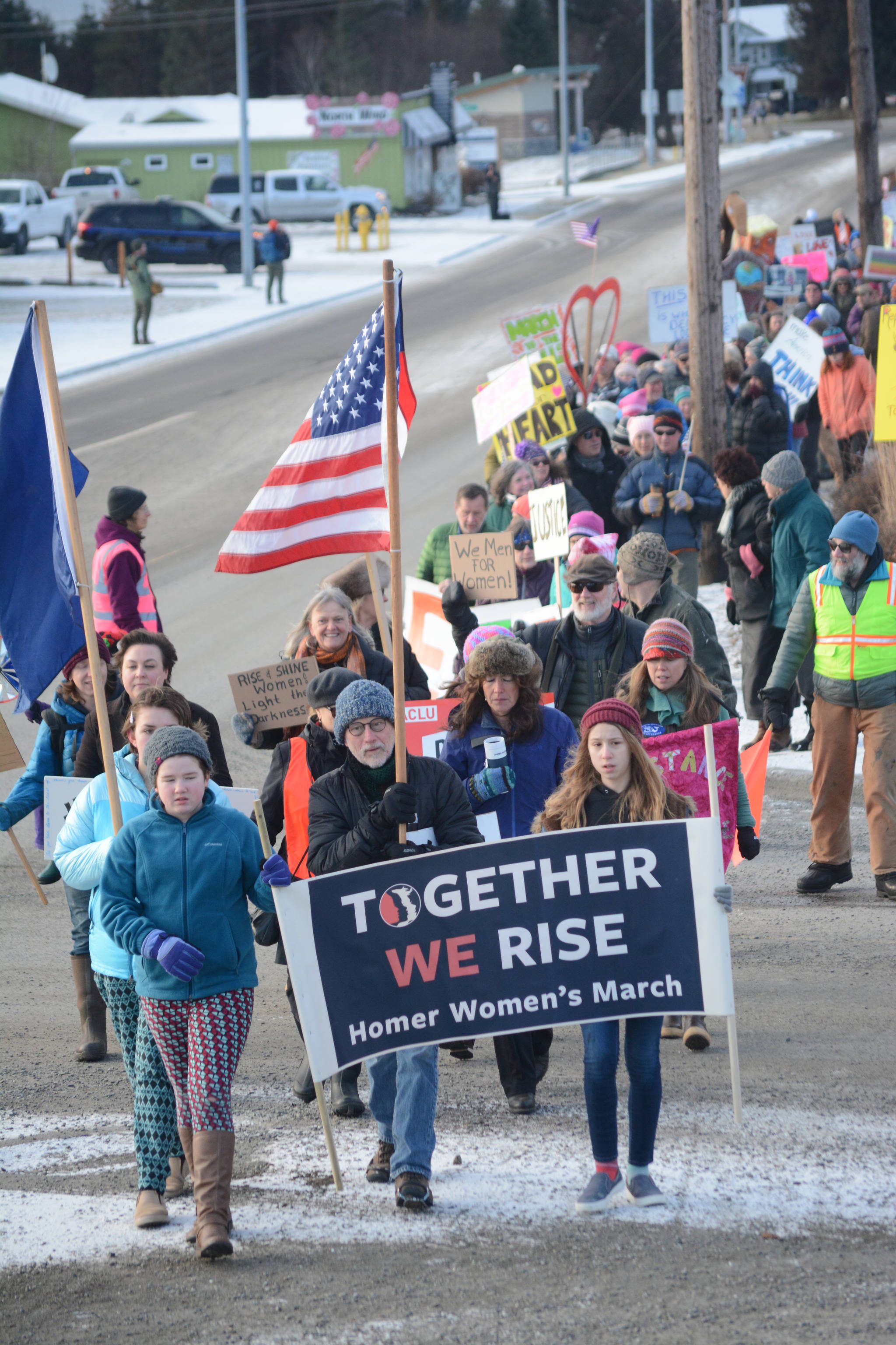 The front of the Homer March for Women crosses Main Street on Saturday. About 700 people walked in the march along Pioneer Avenue on Jan. 20, 2018, in Homer, Alaska. The group of marchers extended from Main Street to Kachemak Way. (Photo by Michael Armstrong/Homer News)