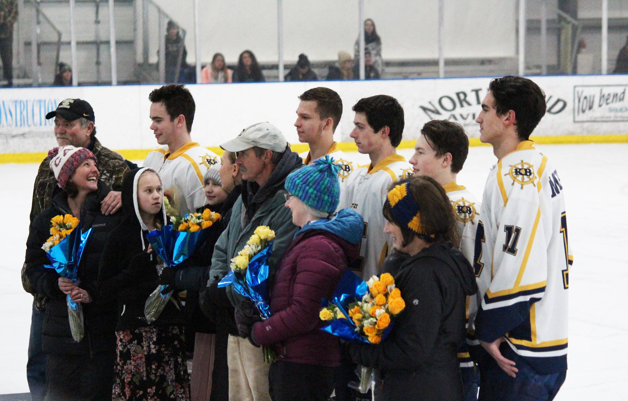 The five seniors on Homer High School’s hockey team, Spencer Warren, Dimitry Kuzmin, Douglas Dean, Tim Blakely and Charlie Menke, pose with their parents during a senior night ceremony at their last home game of the season Thursday, Jan. 25, 2018 at the Kevin Bell Arena in Homer, Alaska. (Photo by Megan Pacer/Homer News)
