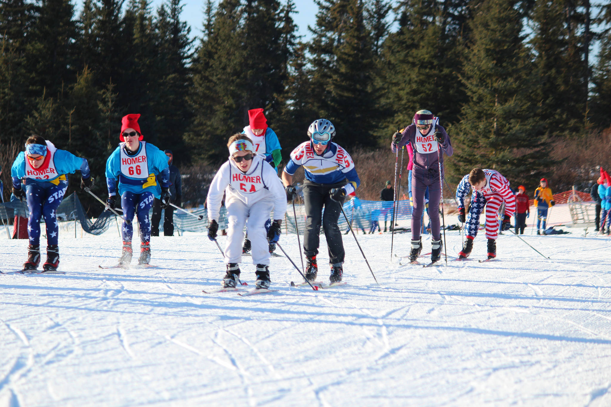 Varsity boy skiers take off from the starting line in a mass start for a 5 kilometer skate ski race Saturday, Feb. 3, 2018 at the Lookout Mountain Ski Trails near Homer, Alaska. Satruday was costume day for the athletes from Homer, Seward, Kenai and Soldotna. (Photo by Megan Pacer/Homer News)
